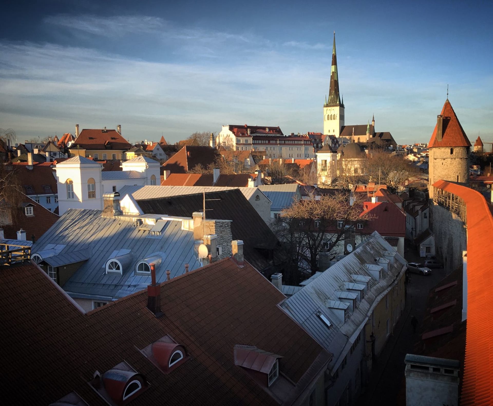 Los tejados del casco antiguo medieval de Tallin con la aguja de la iglesia de San Olaf elevándose sobre tejas de terracota y antiguas murallas de piedra