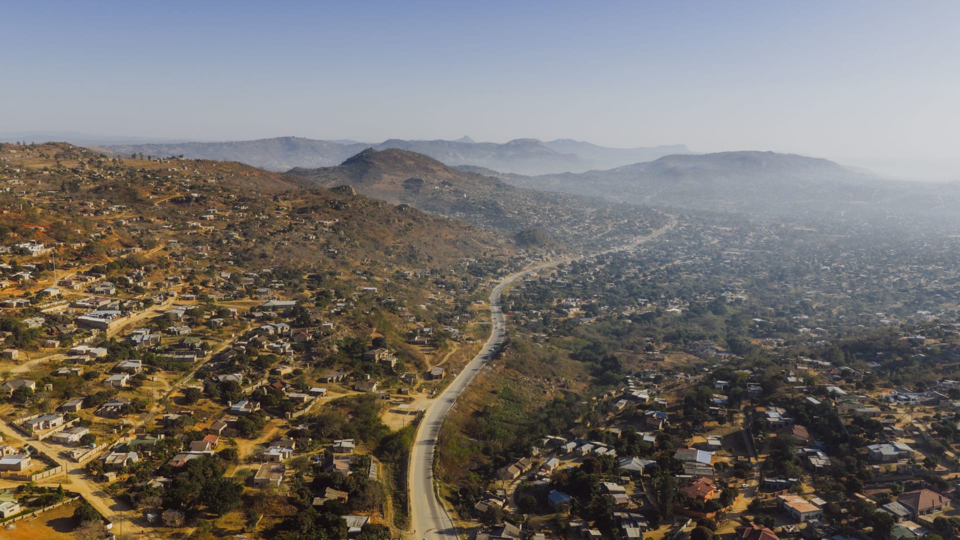 The enormous bare granite dome of Sibebe Rock rising above surrounding forest and green hills near Mbabane, its smooth face catching the morning light