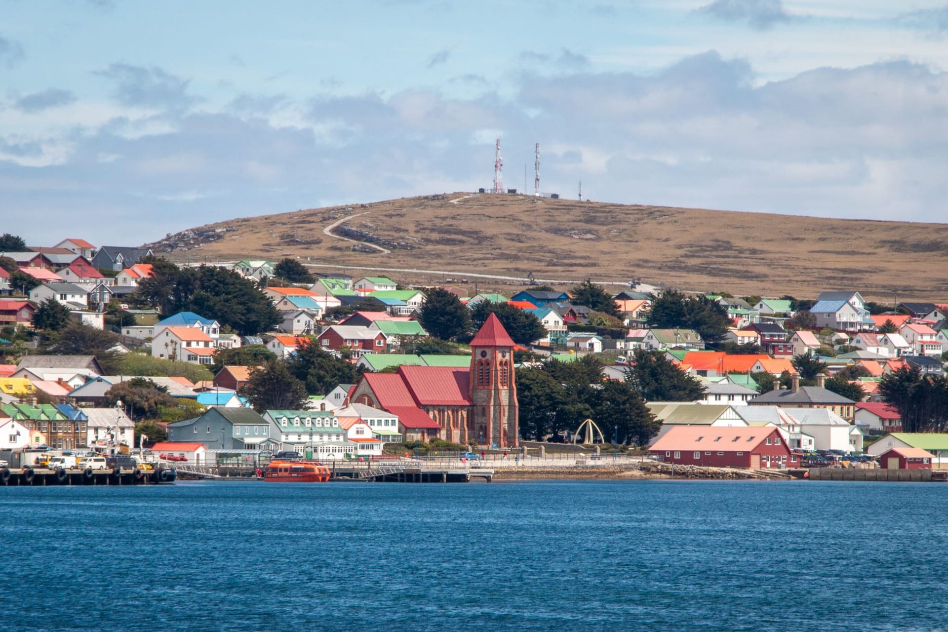 The quartzite ridgeline of Mount William above Stanley, with the town and harbour spread across the lowland below and the South Atlantic beyond