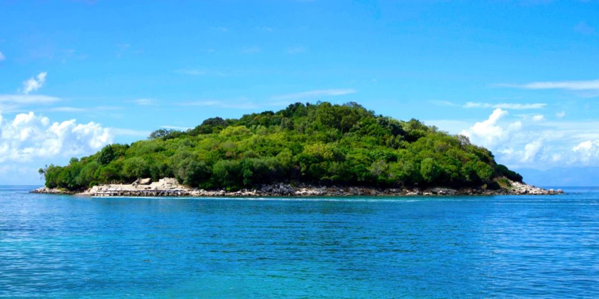 Kitesurfer skimming across the wind-whipped turquoise channel between Nananu-i-Ra Island and mainland Viti Levu, Fiji