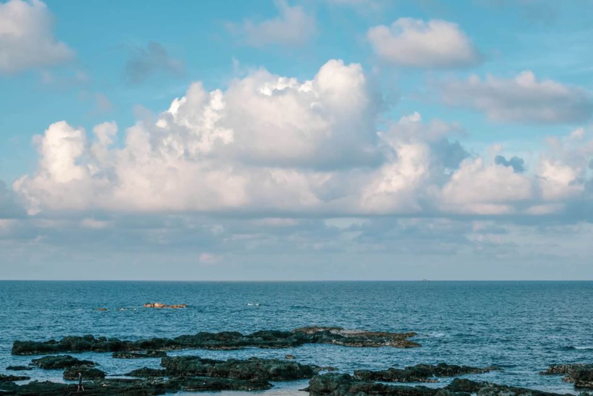 La arena gris dorada de la Playa Wailoaloa cerca de Nadi al atardecer, con botes de pesca varados en la orilla