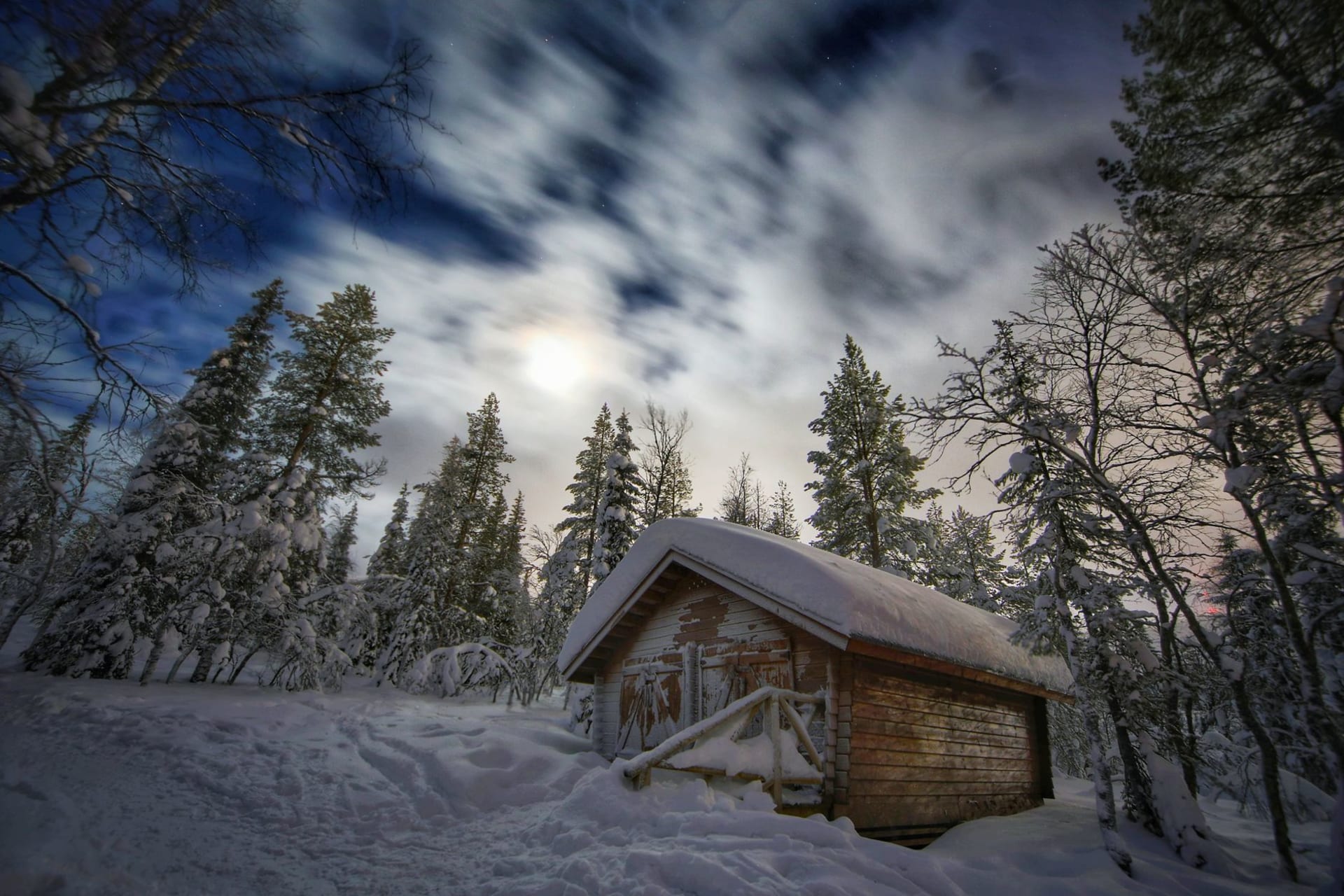 Lake Inari in the blue hour of an Arctic winter, the vast frozen lake stretching to the horizon under a pale violet sky, snow-covered pines framing the foreground