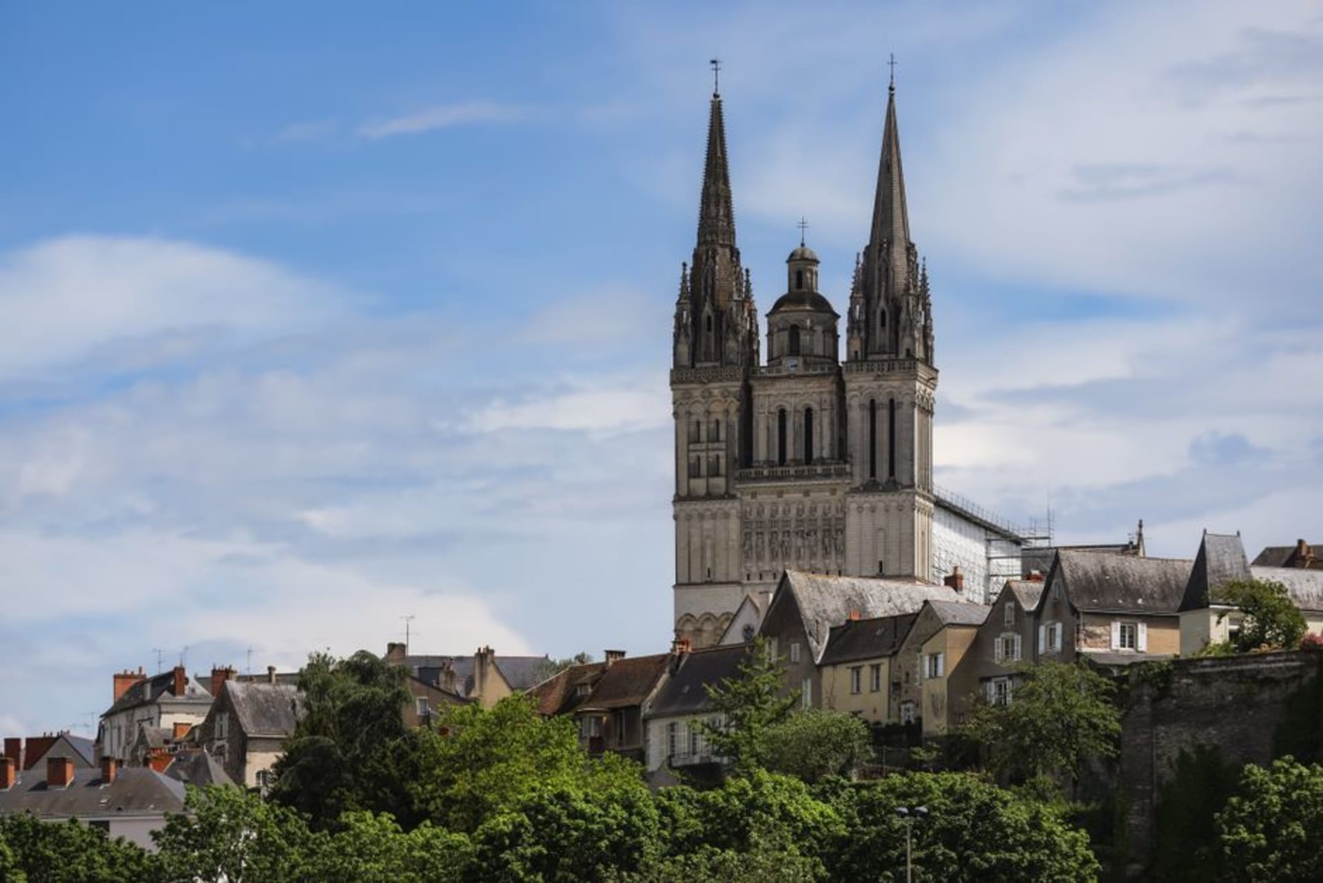 The dark slate towers and moated ramparts of the Château d'Angers under a bright sky
