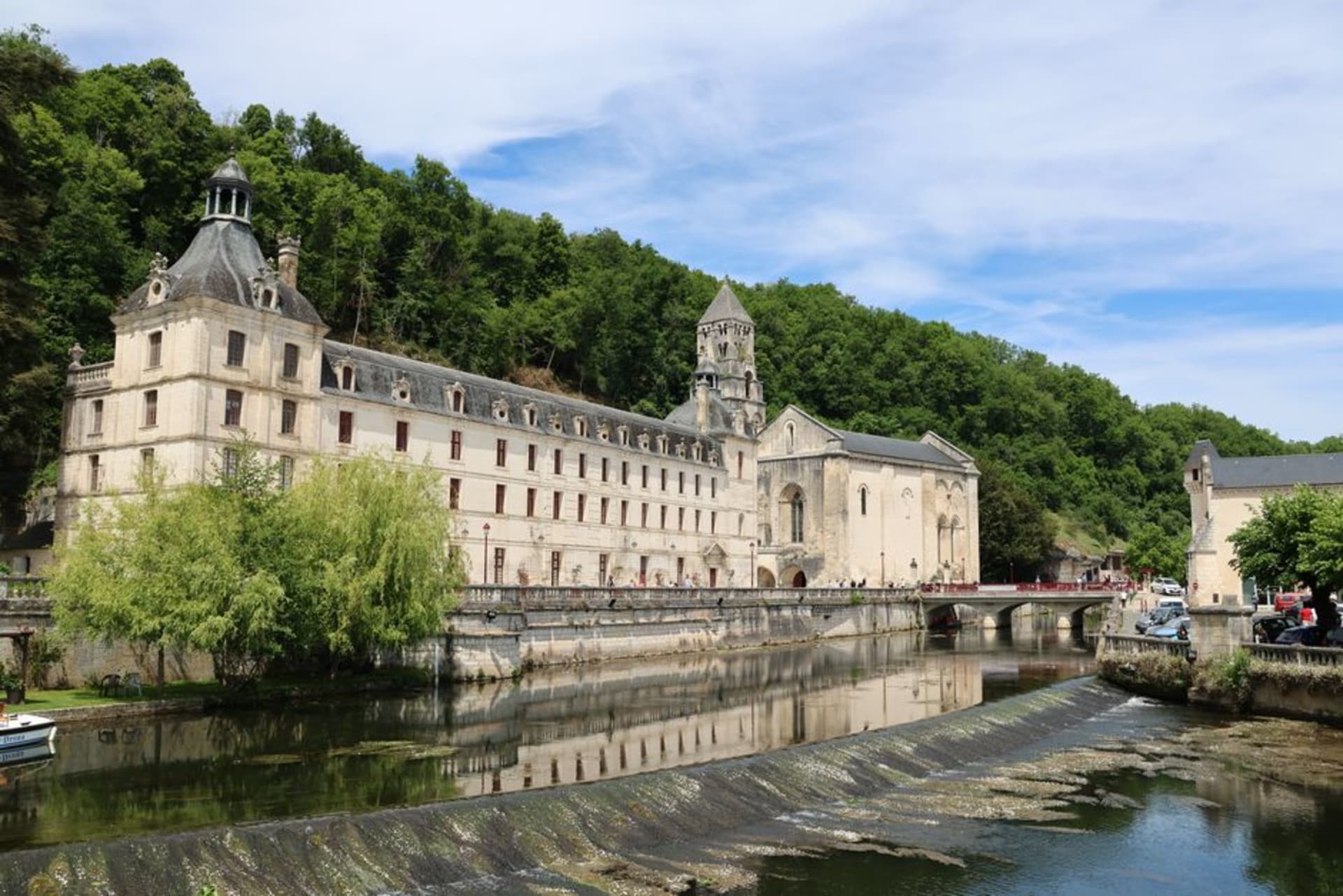 The Benedictine abbey and bell tower of Brantôme reflected in the still water of the River Dronne