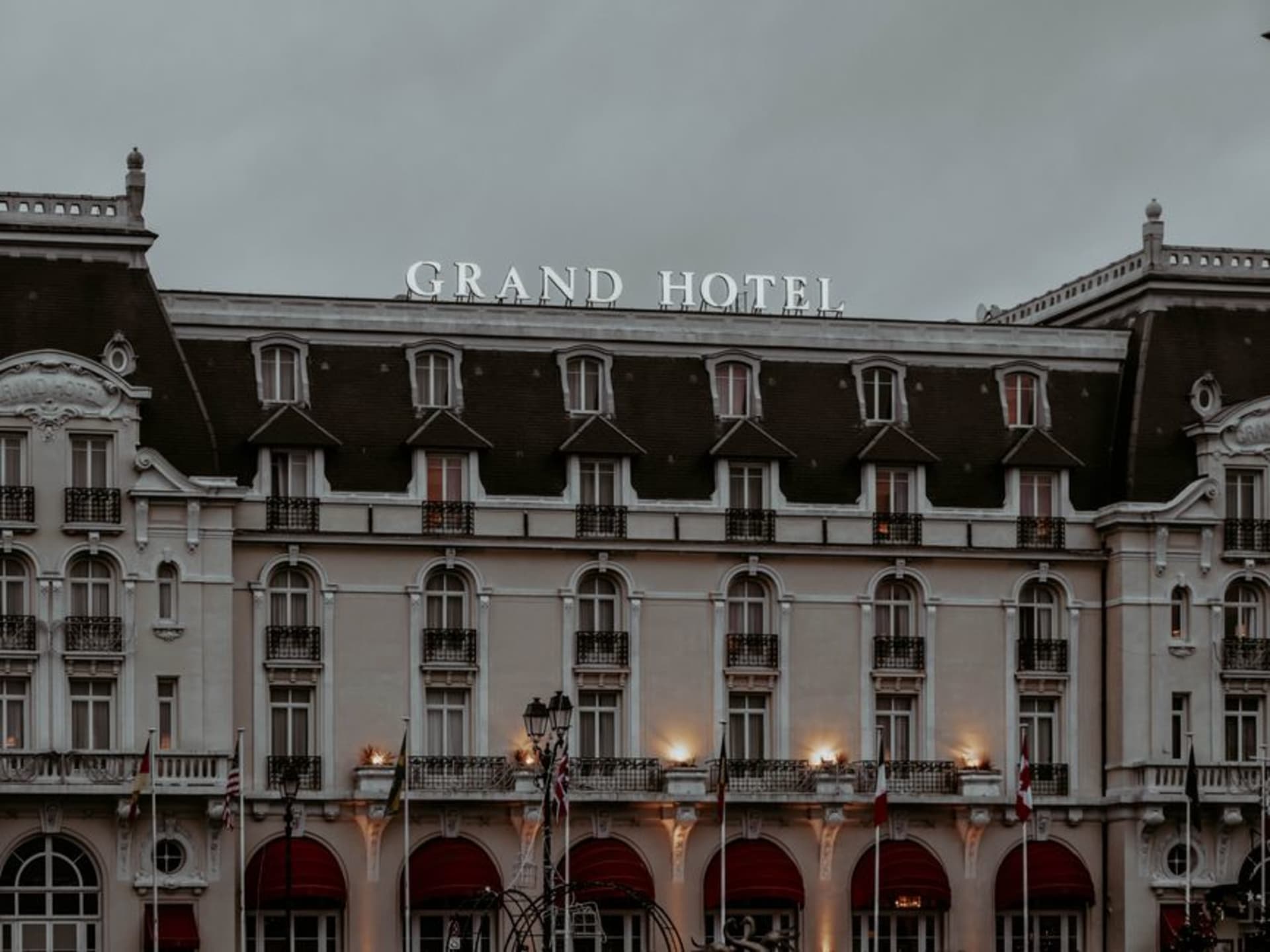 The curved white Belle Époque façade of the Grand Hôtel de Cabourg overlooking the beach and boardwalk