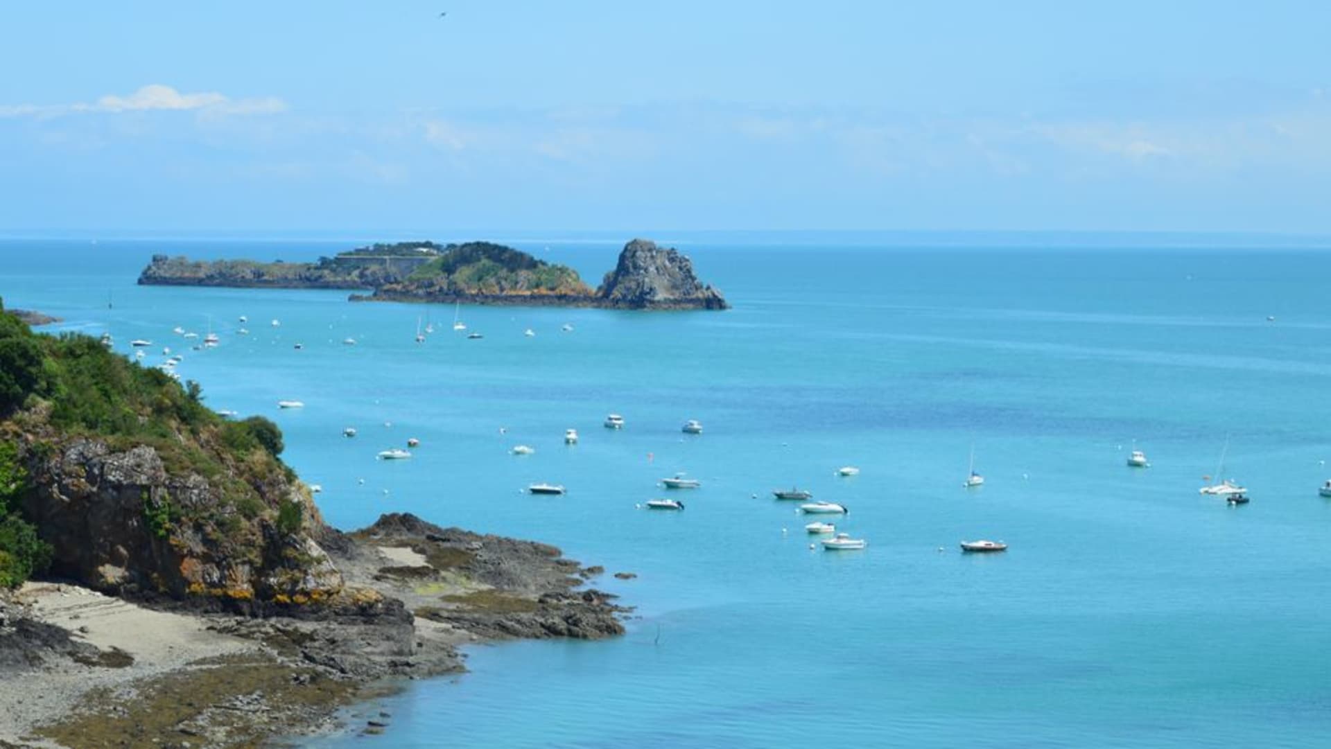 Oyster stalls along the harbor wall at Cancale with the bay and oyster beds visible behind them