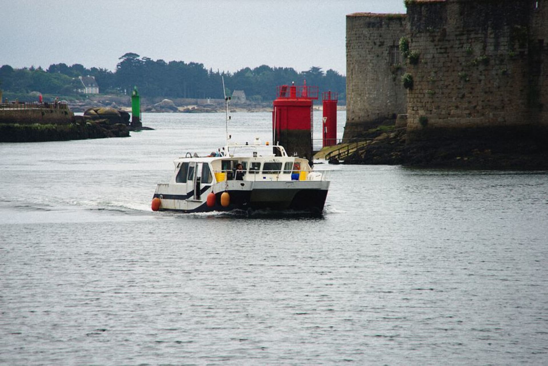 The fortified granite walls of the Ville Close island in Concarneau's harbour surrounded by fishing boats