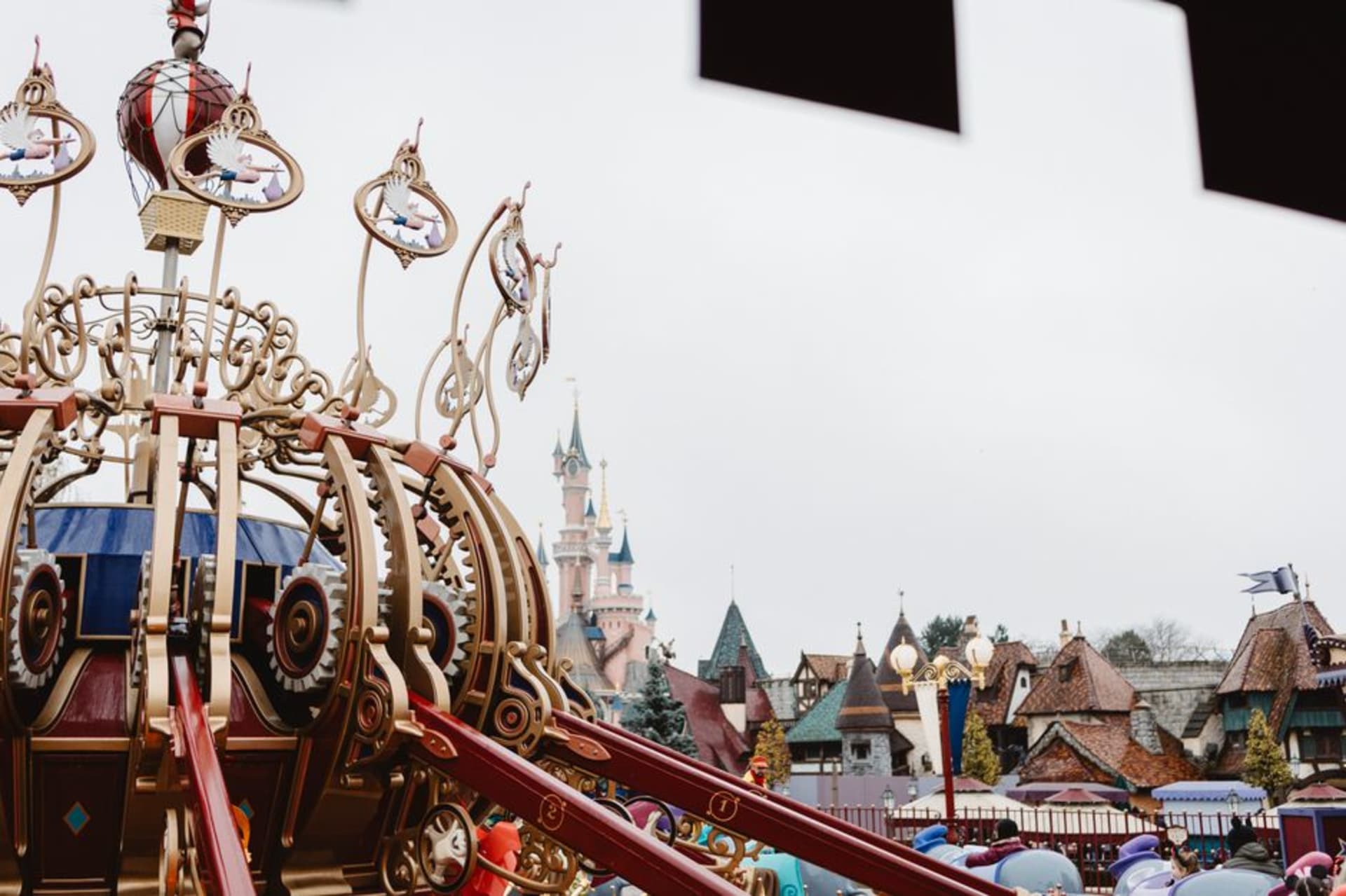 The pink turrets and blue spires of Le Château de la Belle au Bois Dormant at the center of Disneyland Paris