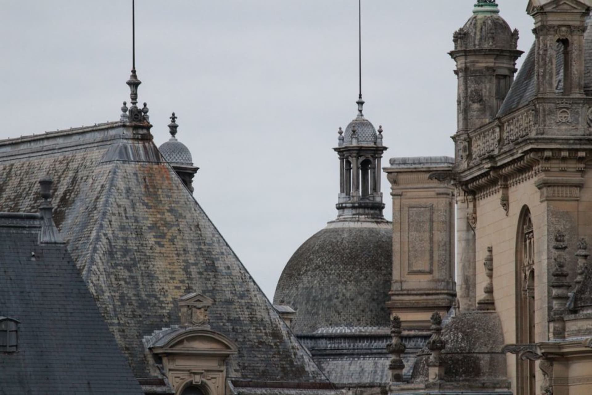 The ornate turrets of the Palais Bénédictine rising above the rooftops of Fécamp with chalk cliffs behind