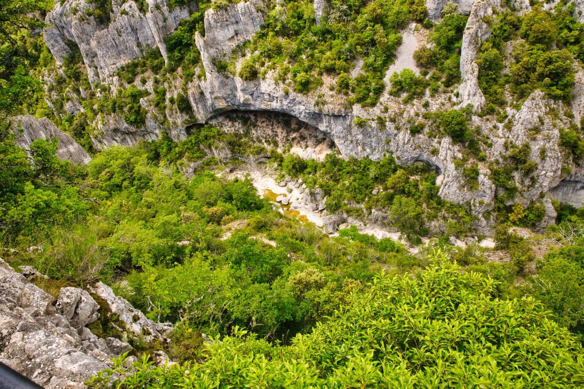 The medieval village of Minerve rising above the limestone gorges of the Brian and Cesse rivers, its stone tower catching late afternoon light against a pale sky
