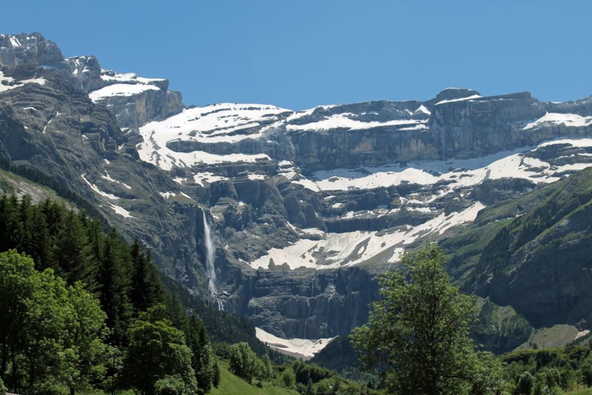 The vast rock amphitheatre of the Cirque de Gavarnie with waterfalls streaking down its cliffs above the village