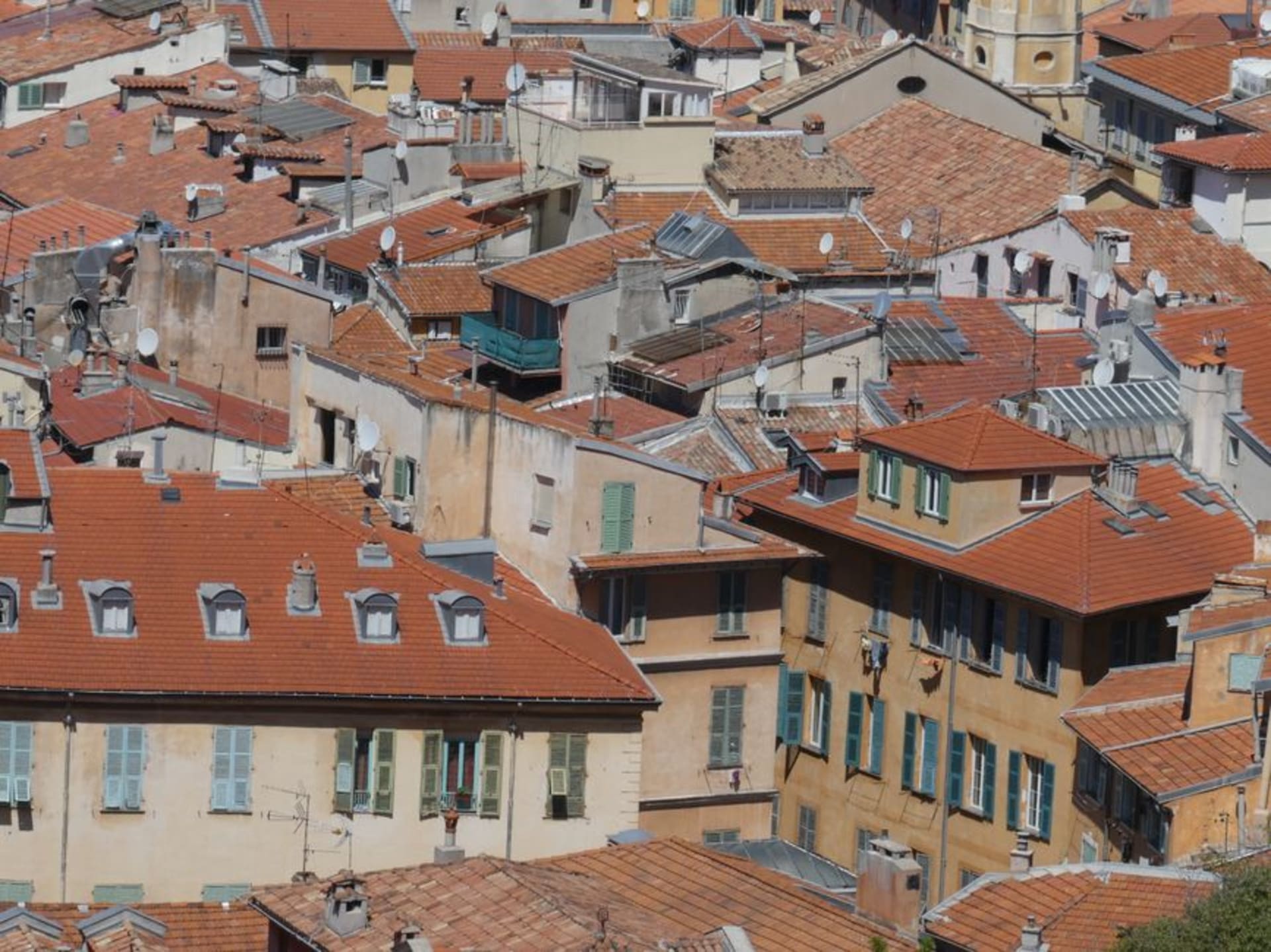The hillside old town of Grasse with terracotta rooftops and the surrounding hills where flowers are grown for perfume
