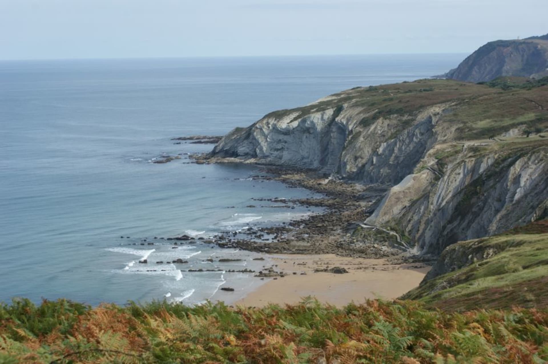 Hendaye's long sandy beach curving toward the mouth of the Bidasoa river with the hills of Spain visible across the water