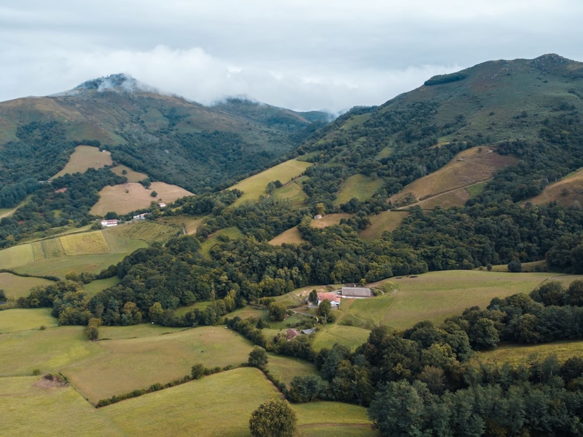 The village of Les Gets with traditional chalets and a church spire set against green Portes du Soleil hillsides in summer