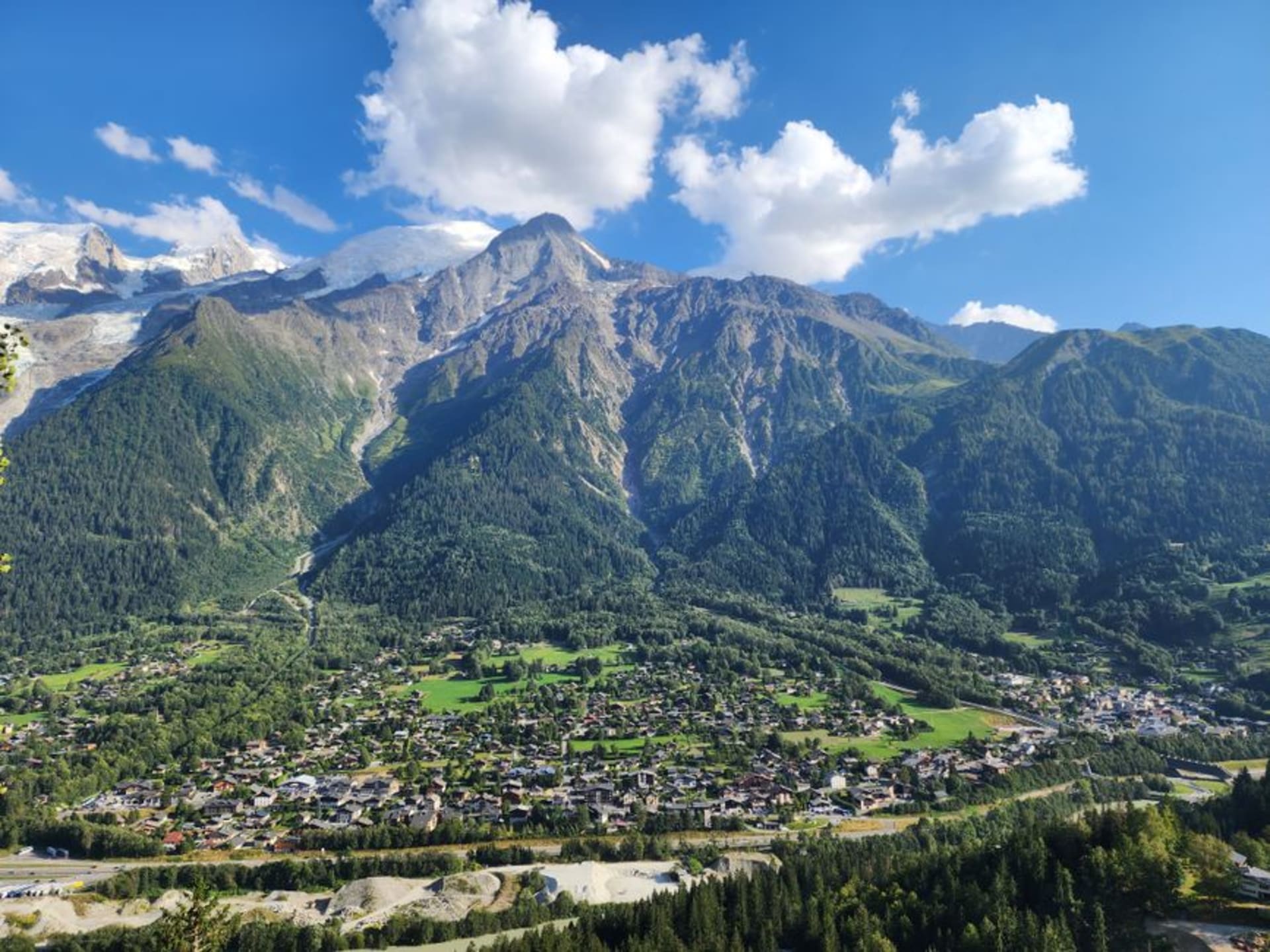 The village of Les Houches in the Chamonix valley with the Bossons glacier and Mont Blanc massif rising behind pine forest