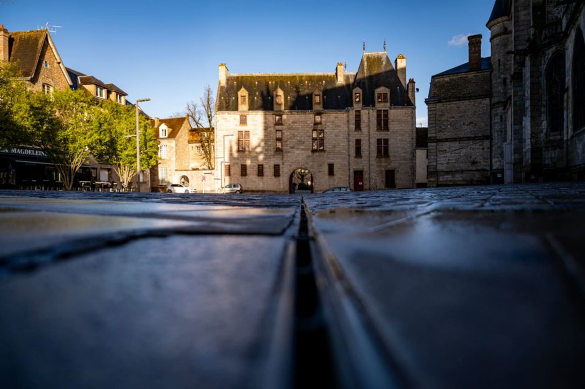 The granite square and church spire of Locronan with weavers' houses lining the cobbled space