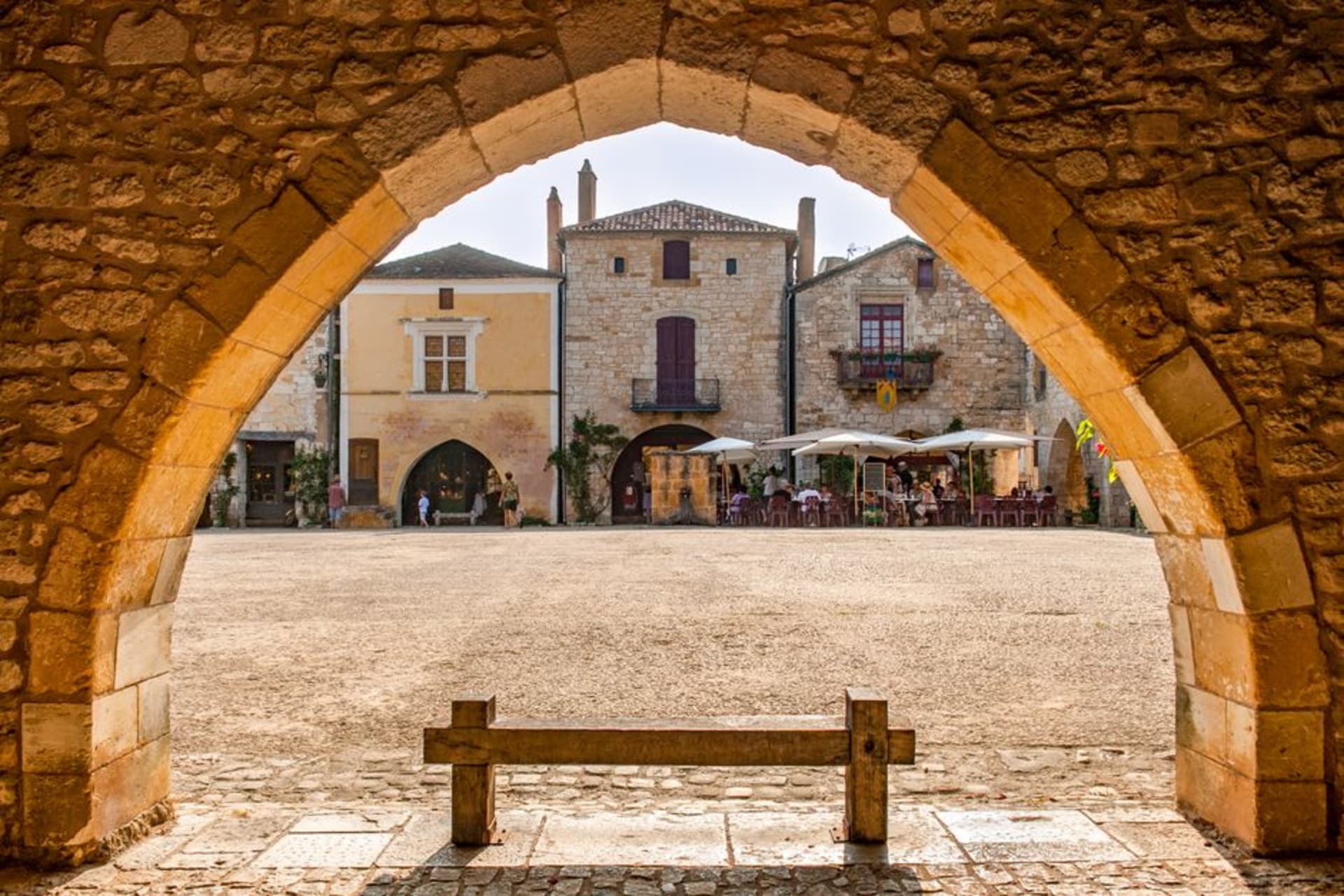 The arcaded stone square of Monpazier's central marketplace with a covered timber market hall in the middle