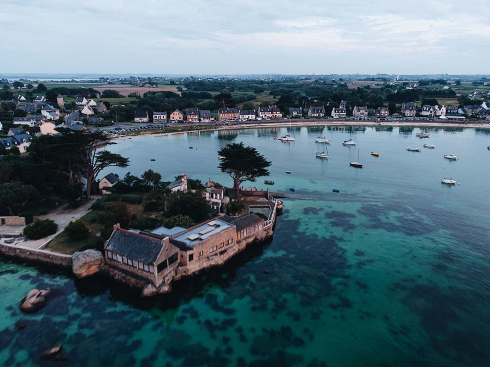 Pink granite houses and the ornate bell tower of the church of Notre-Dame-de-Croaz-Batz overlooking the harbor at Roscoff