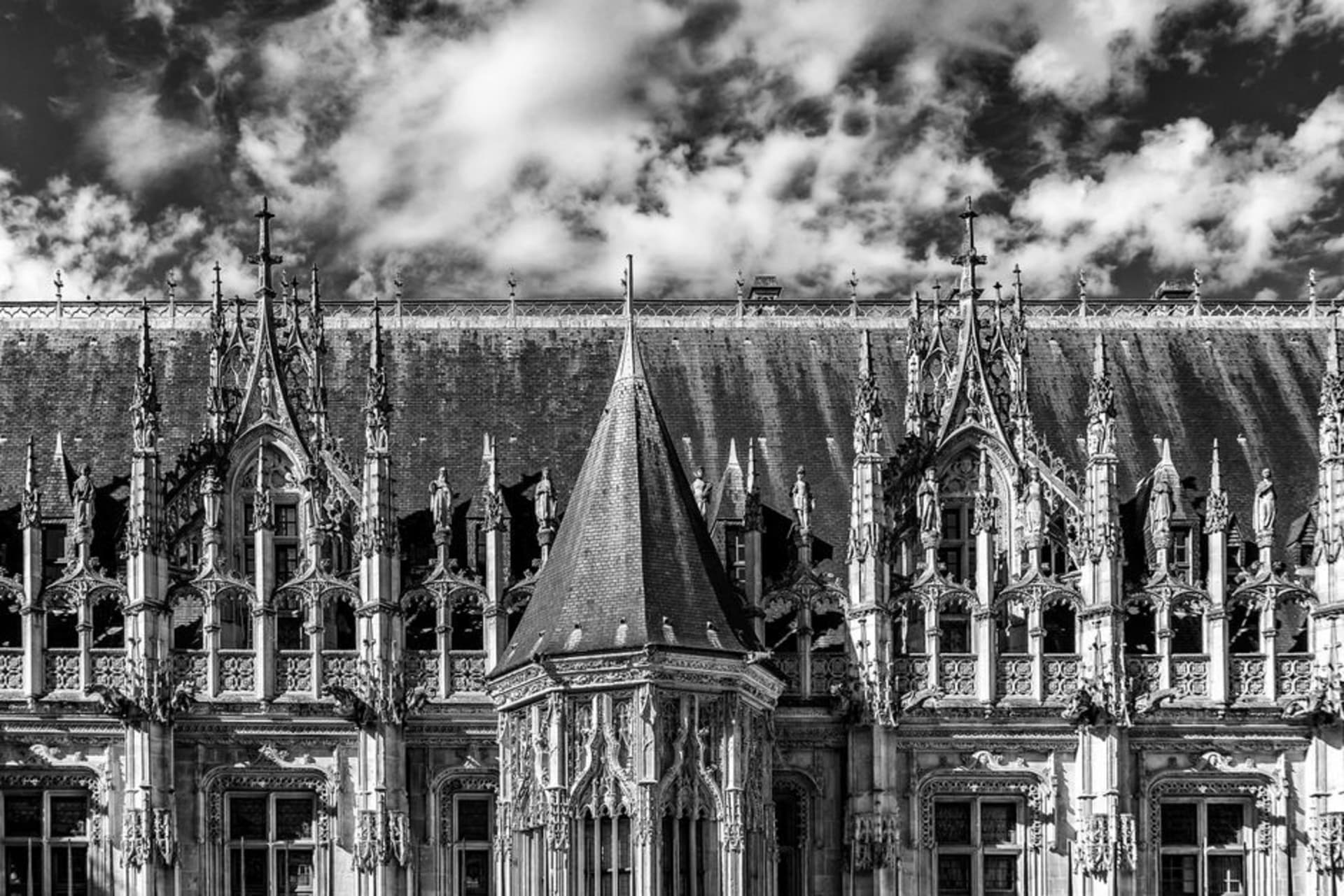 The Gros-Horloge astronomical clock arching over a cobbled street in Rouen with the cathedral spire beyond