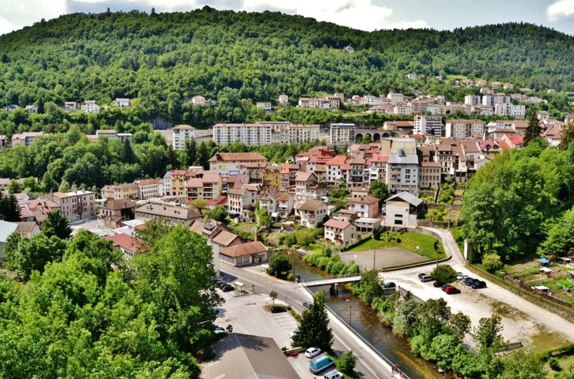 The town of Saint-Claude packed into a steep river gorge with a Gothic cathedral tower rising above the rooftops