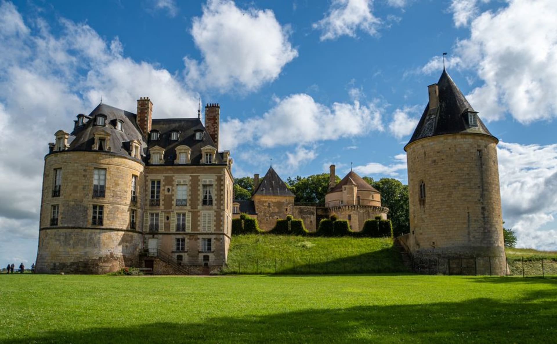 The moated medieval château of Sully-sur-Loire reflected in its still water, with round corner towers and a steep grey slate roof