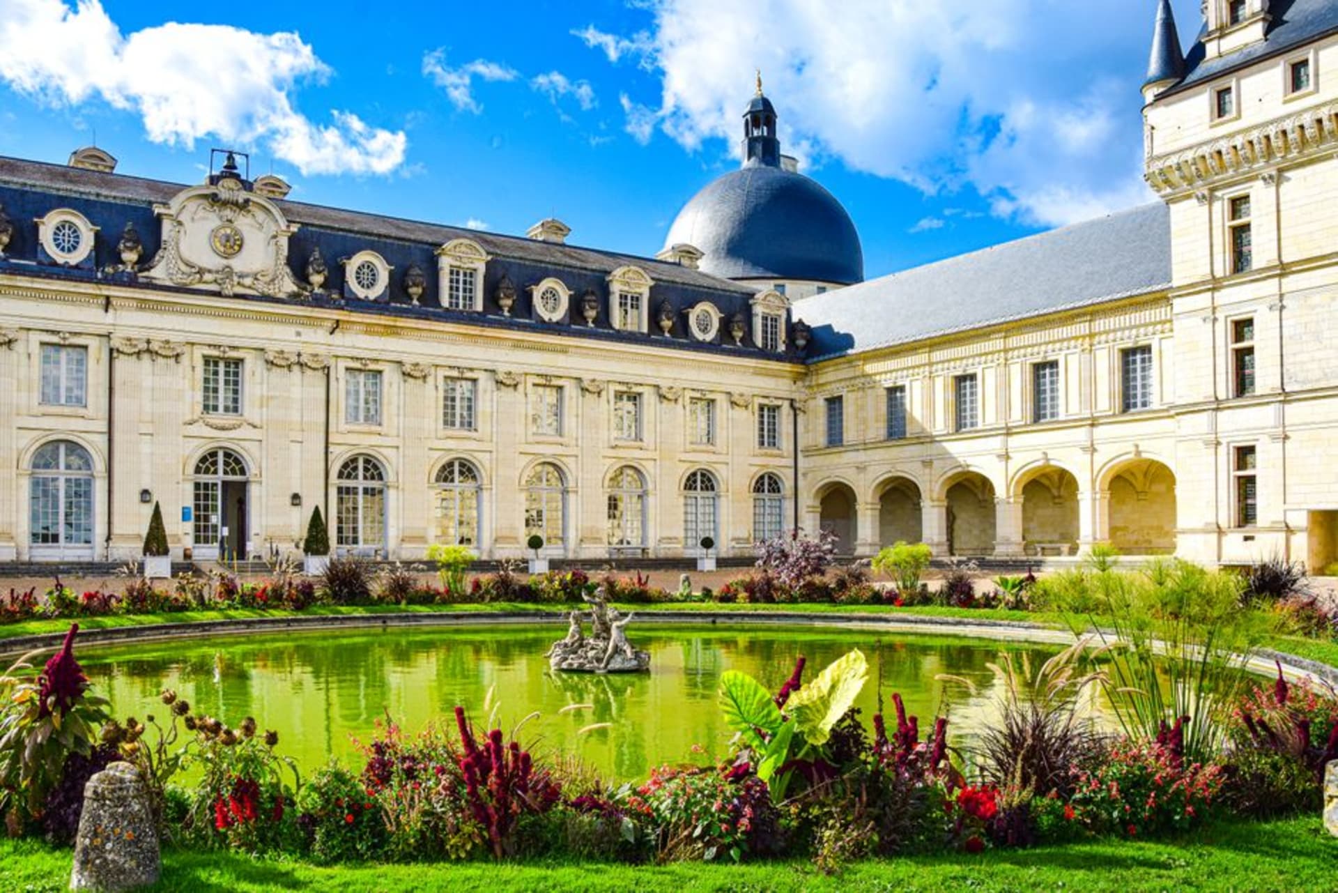 The domed corner towers of the Château de Valençay rising above formal gardens on a clear afternoon