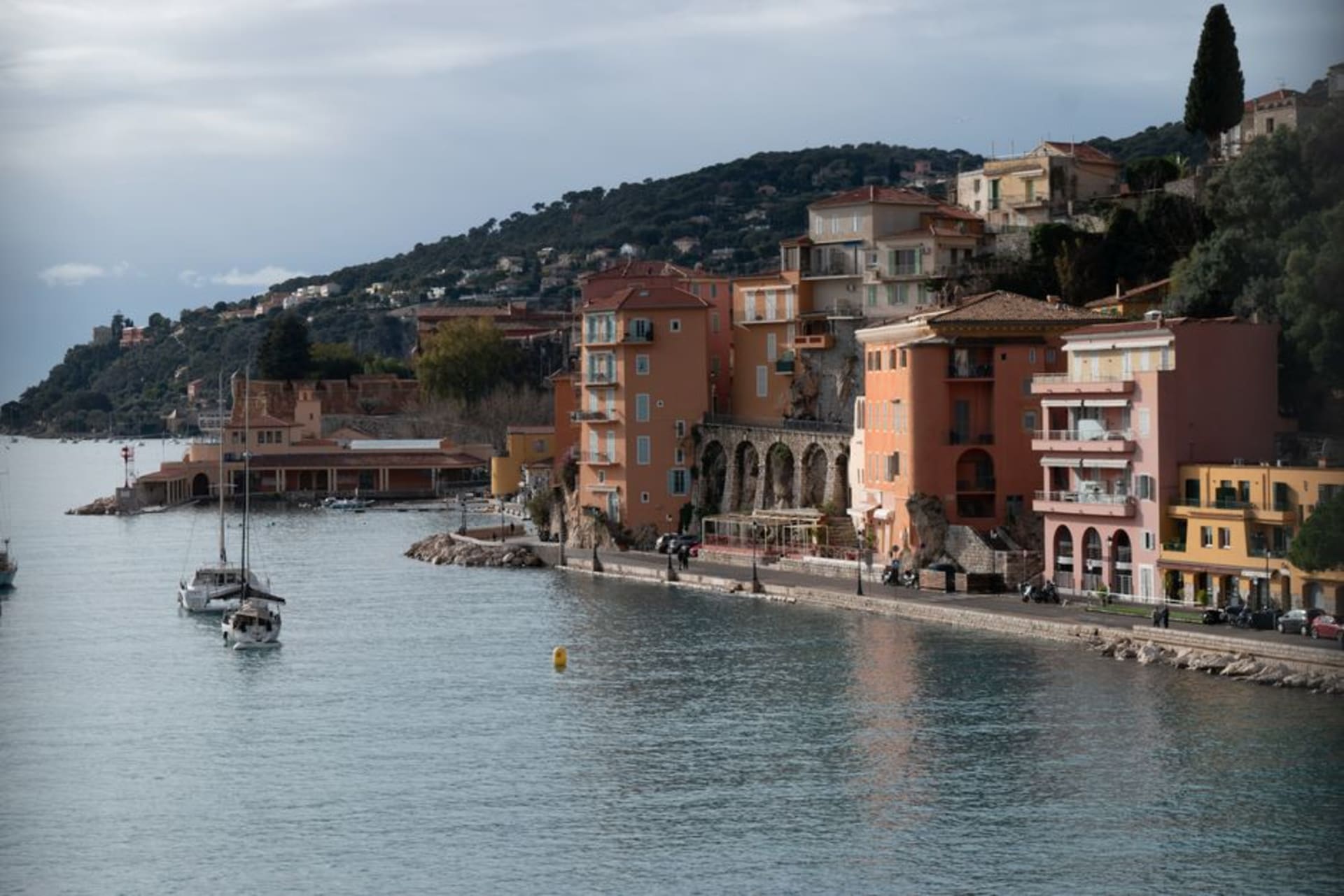 Colourful old buildings lining the waterfront of Villefranche-sur-Mer above its deep natural harbour