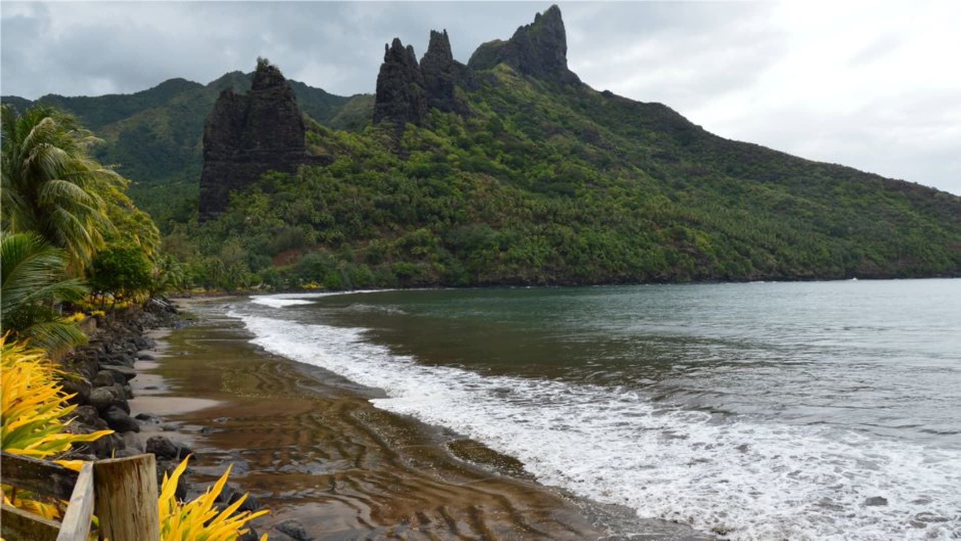 La Baie des Vierges à Fatu Hiva avec d'imposantes aiguilles de roche volcanique flanquant une crique étroite d'un bleu profond