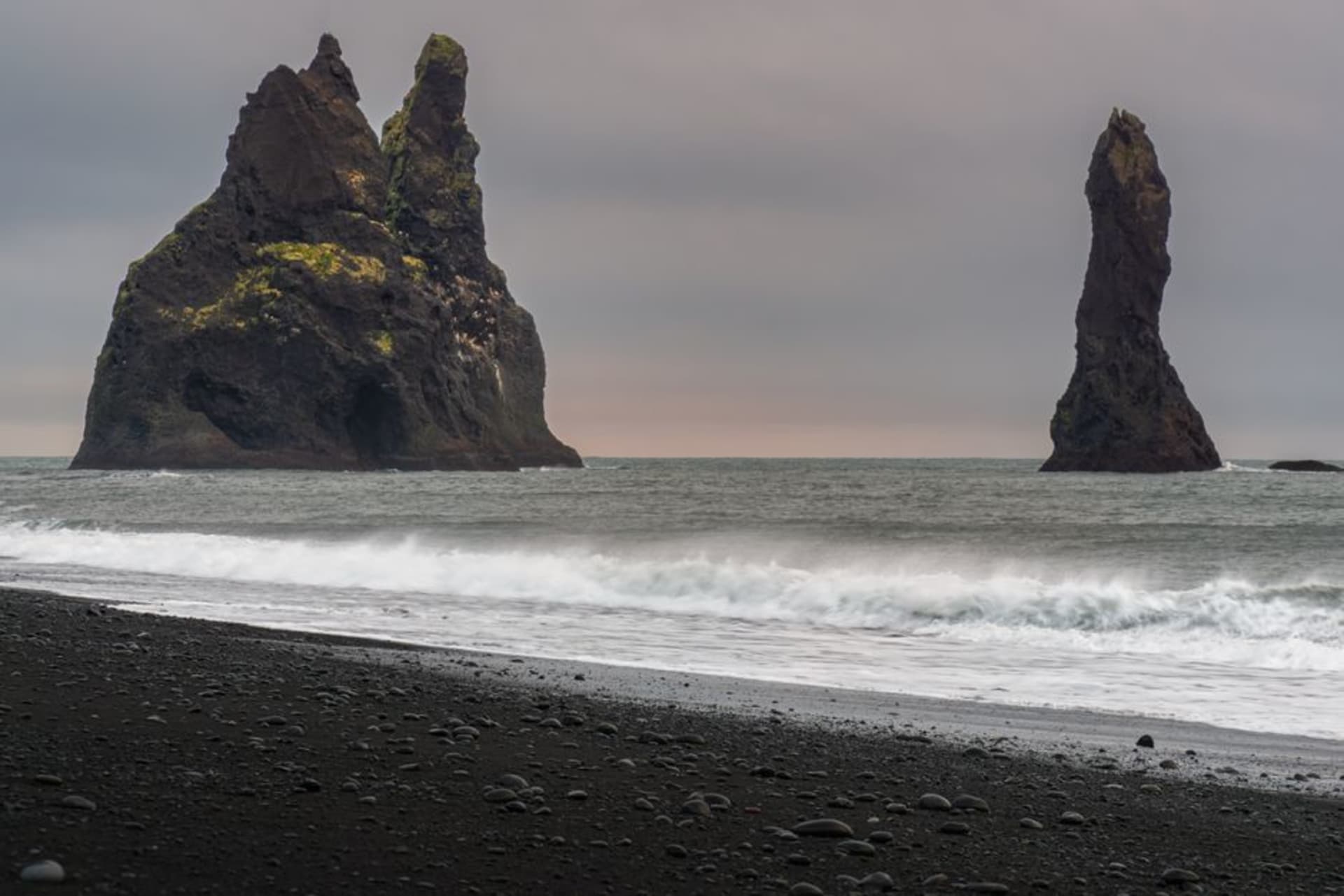 Dramatic volcanic basalt spires of Ua Pou piercing through low cloud cover above green ridgelines