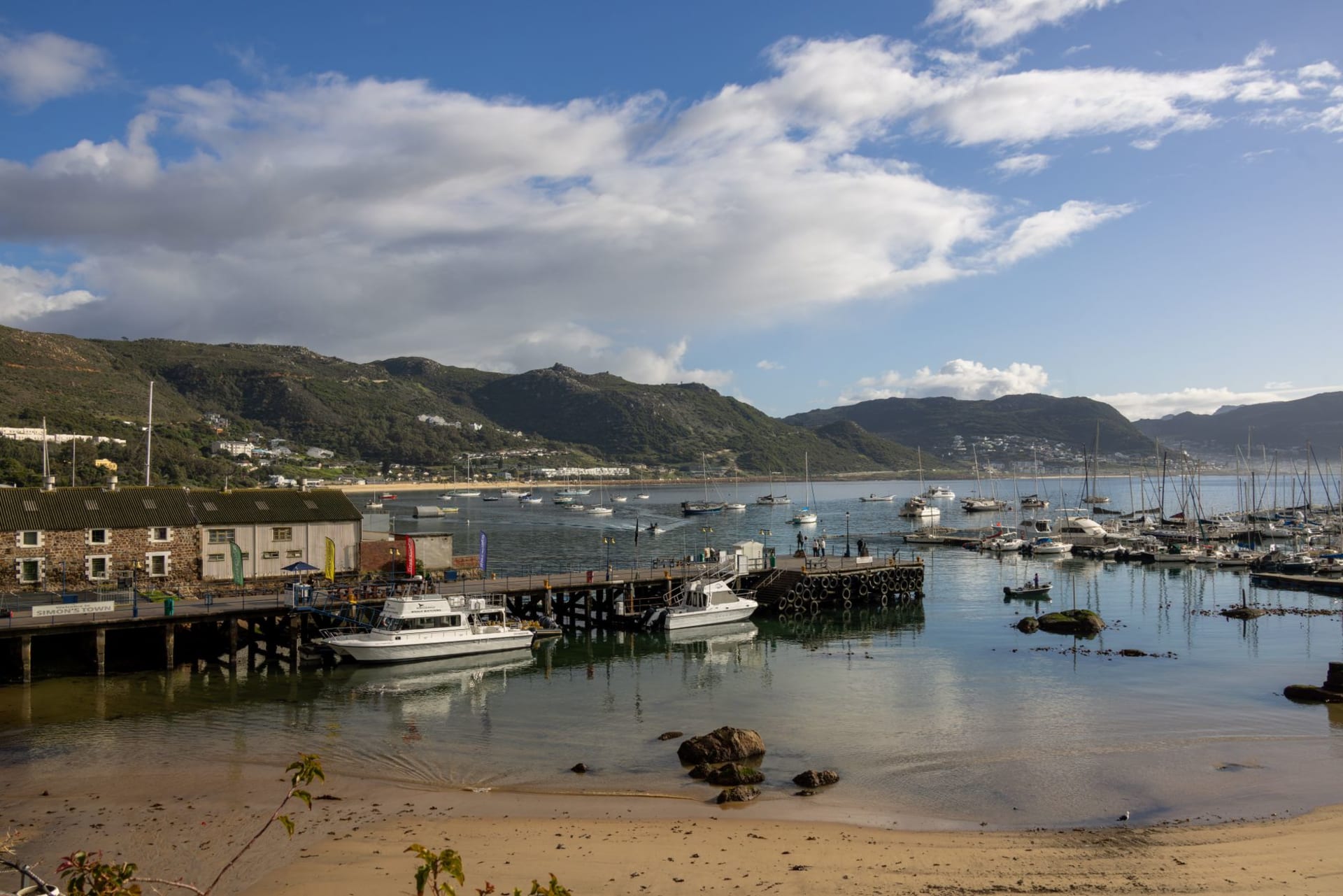 Los Heads de Knysna — dos acantilados de arenisca flanqueando la boca de la laguna — vistos desde el agua al atardecer