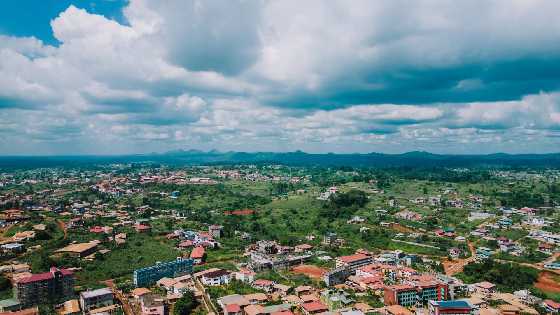 Tejedores trabajando tela kente en telares estrechos en los talleres al aire libre del pueblo de Bonwire, cerca de Kumasi, Ghana