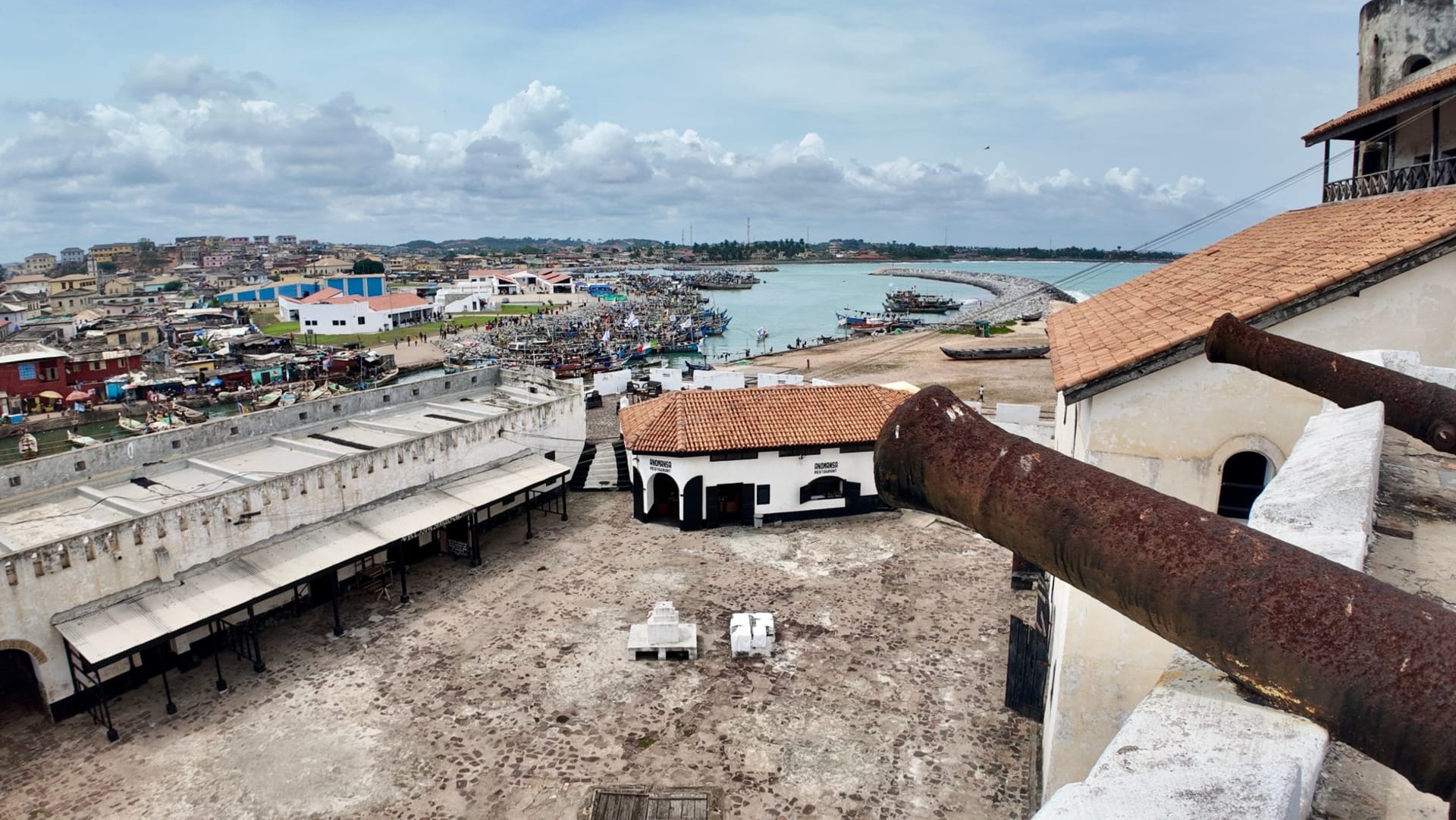 Vue aérienne de Cape Coast avec son architecture coloniale blanchie à la chaux descendant vers l'Atlantique, le fort historique visible en bordure de mer