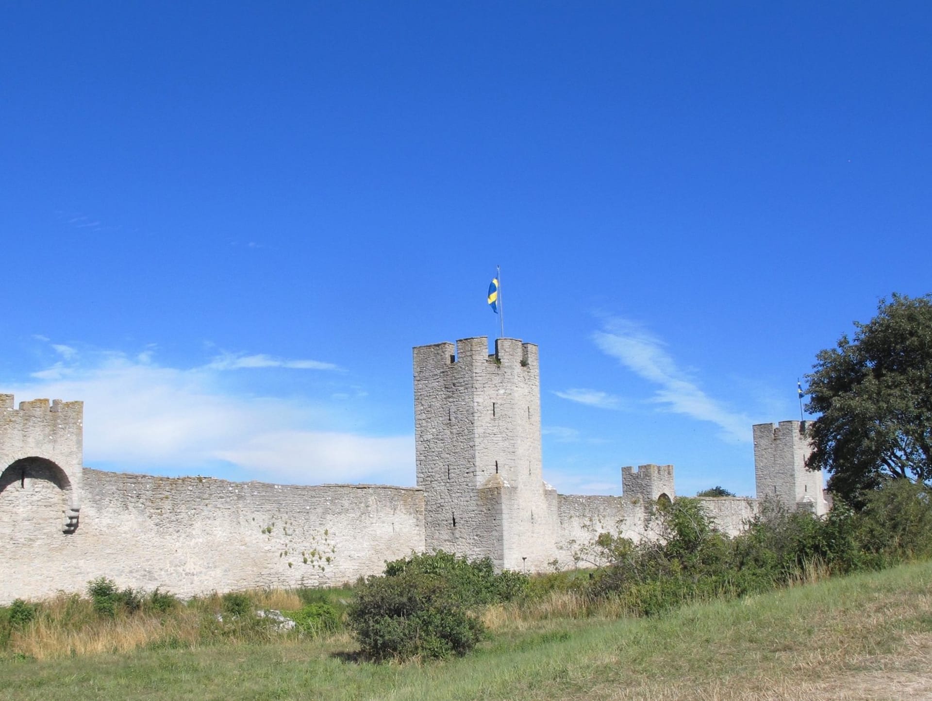 Visby's ancient limestone fortress wall rising against a bright blue sky in Gotland, Sweden