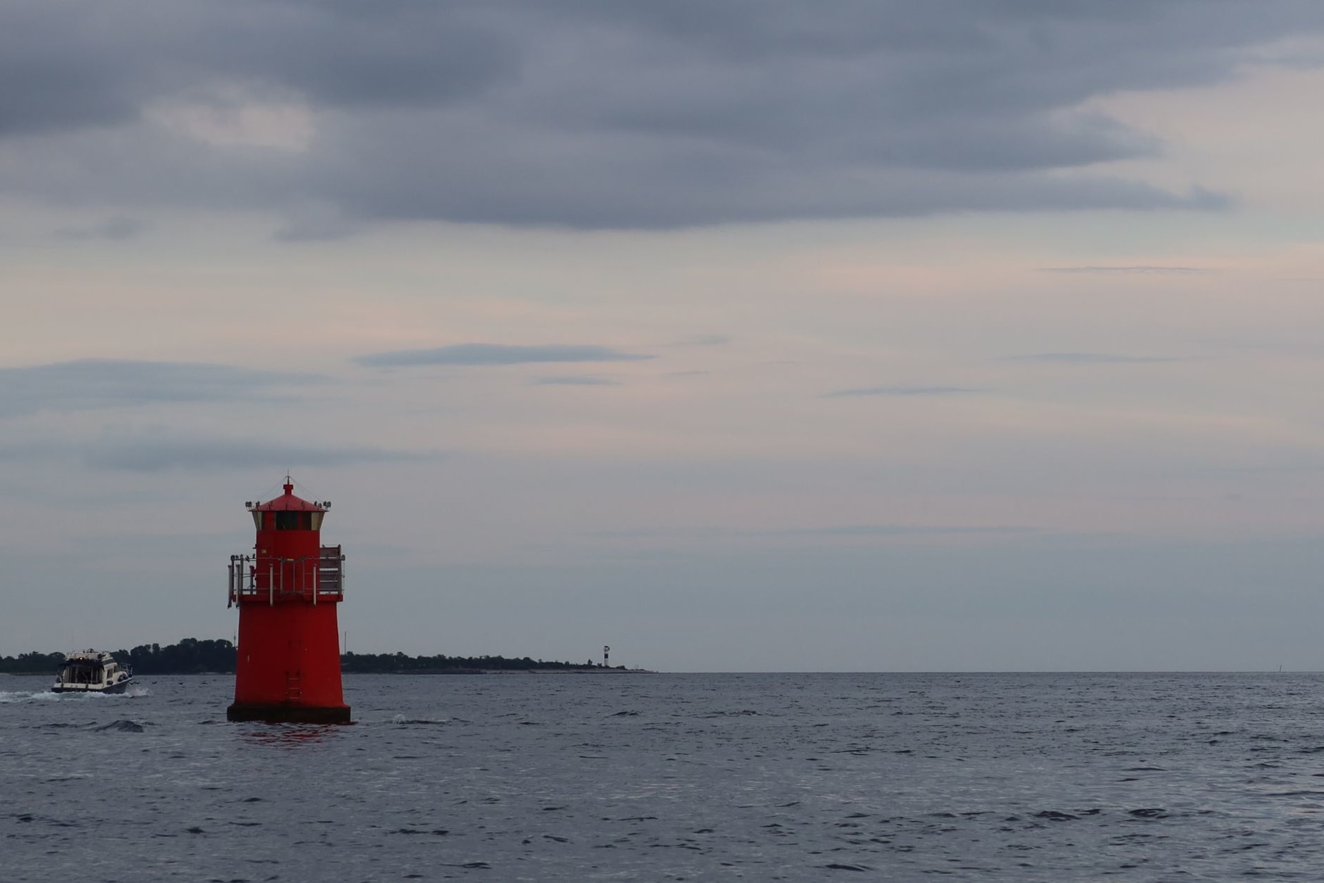 Dramatic limestone raukar sea stacks rising from the Baltic at Hoburgen in golden evening light, white cliff behind
