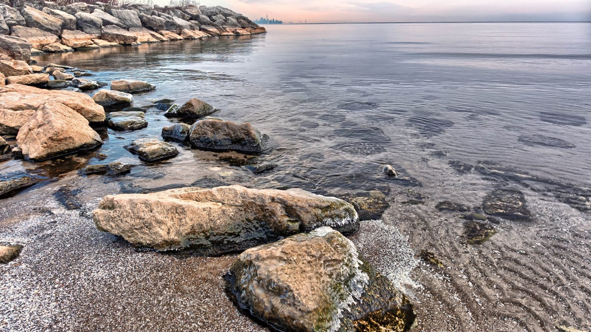 Grand Traverse Bay at golden hour, the water a luminous turquoise, cherry orchards and vineyards visible on the surrounding hills