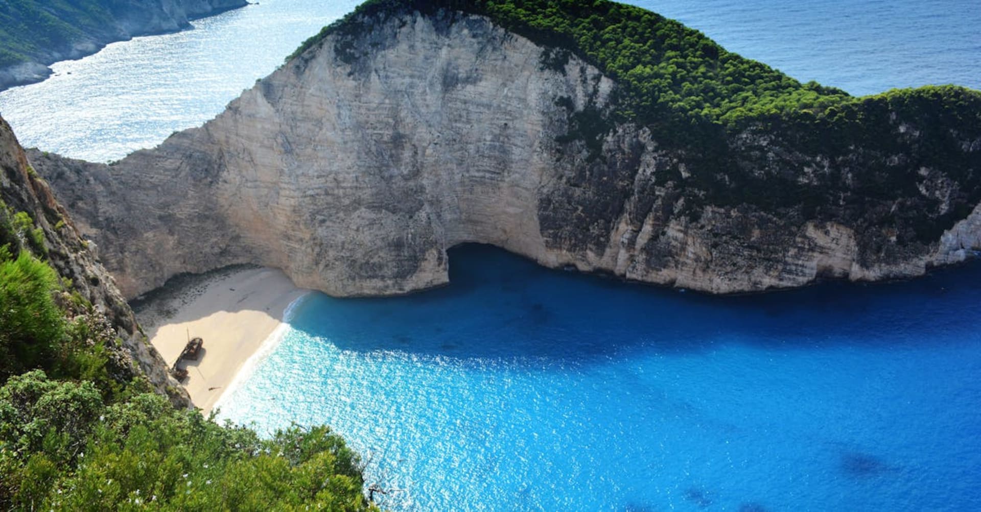 The famous Navagio Shipwreck Beach surrounded by towering white cliffs on Zakynthos