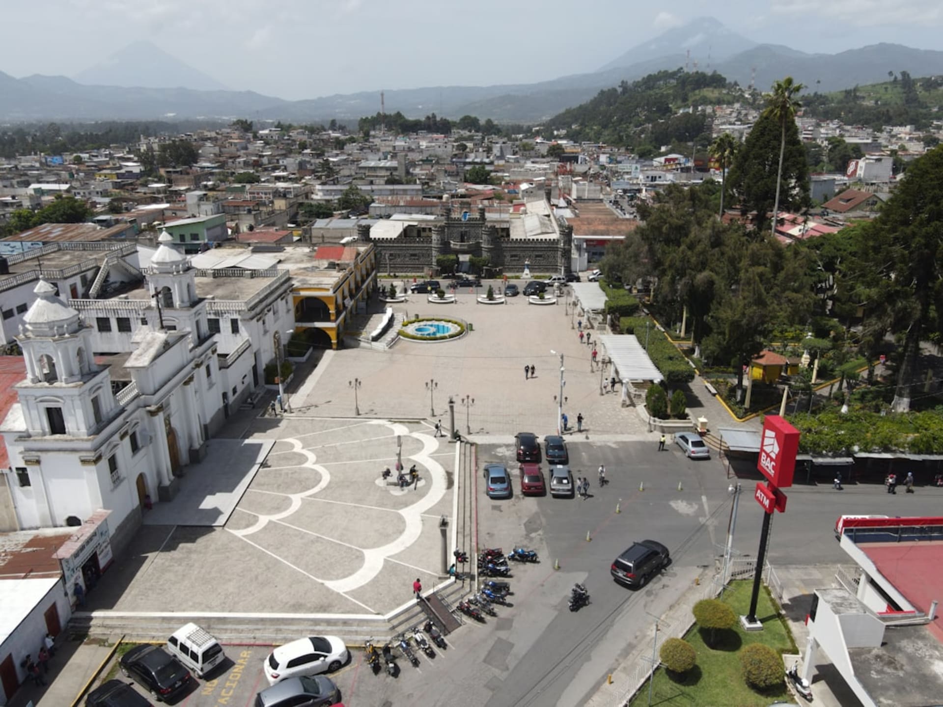La desgastada iglesia colonial de Ciudad Vieja con el Volcán de Agua asomando verde y cercano detrás