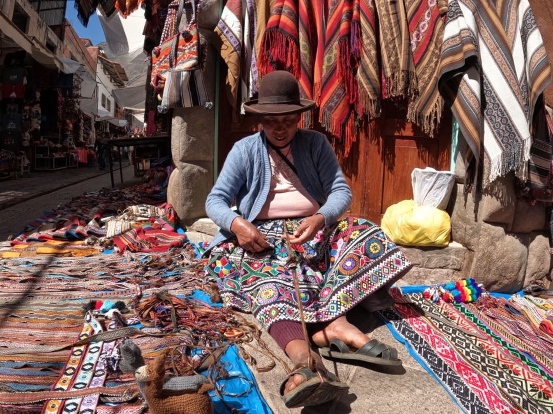 Rows of handwoven wool ponchos and blankets for sale at the Momostenango Saturday market