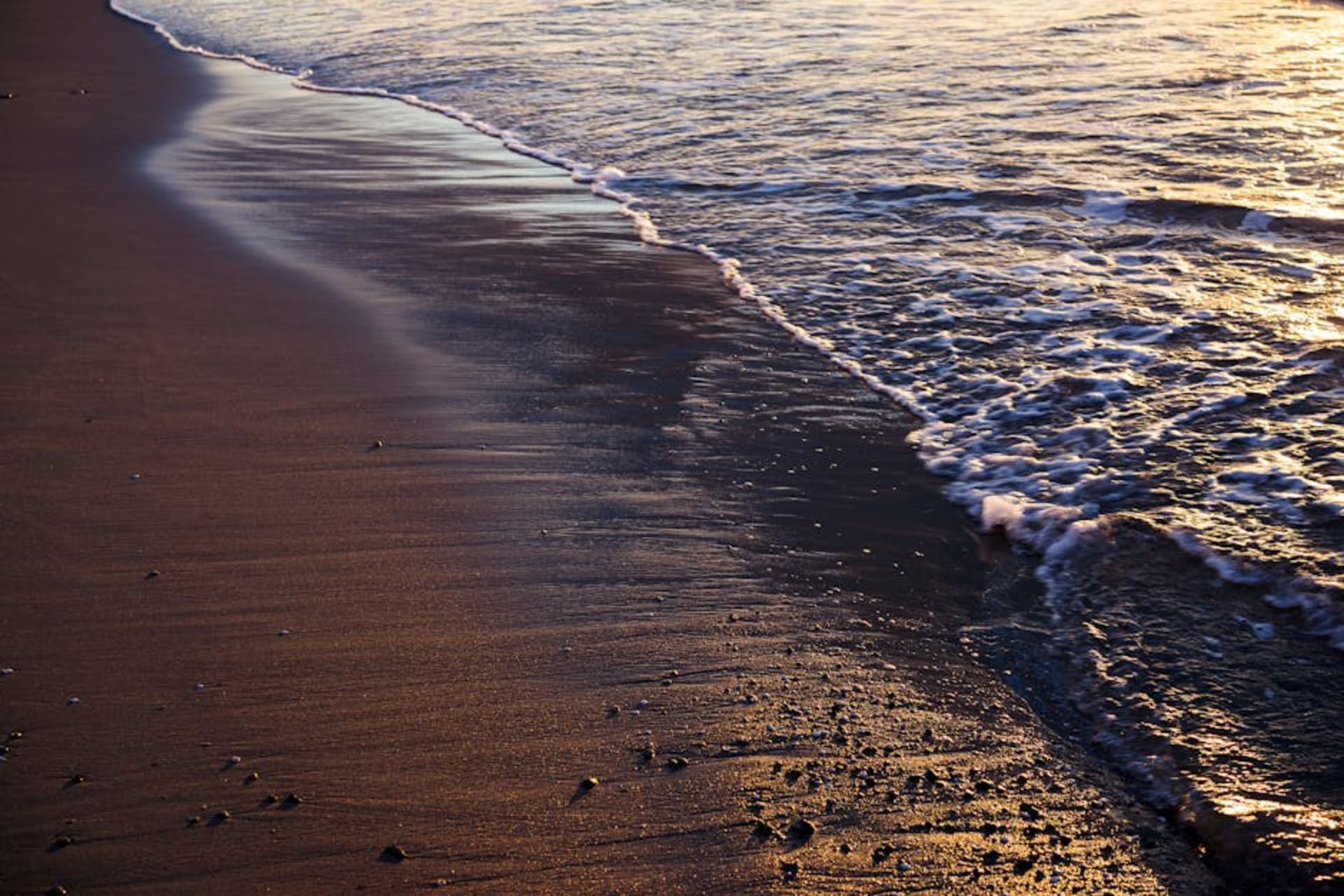 Black sand beach at Monterrico with Pacific waves and dramatic sunset