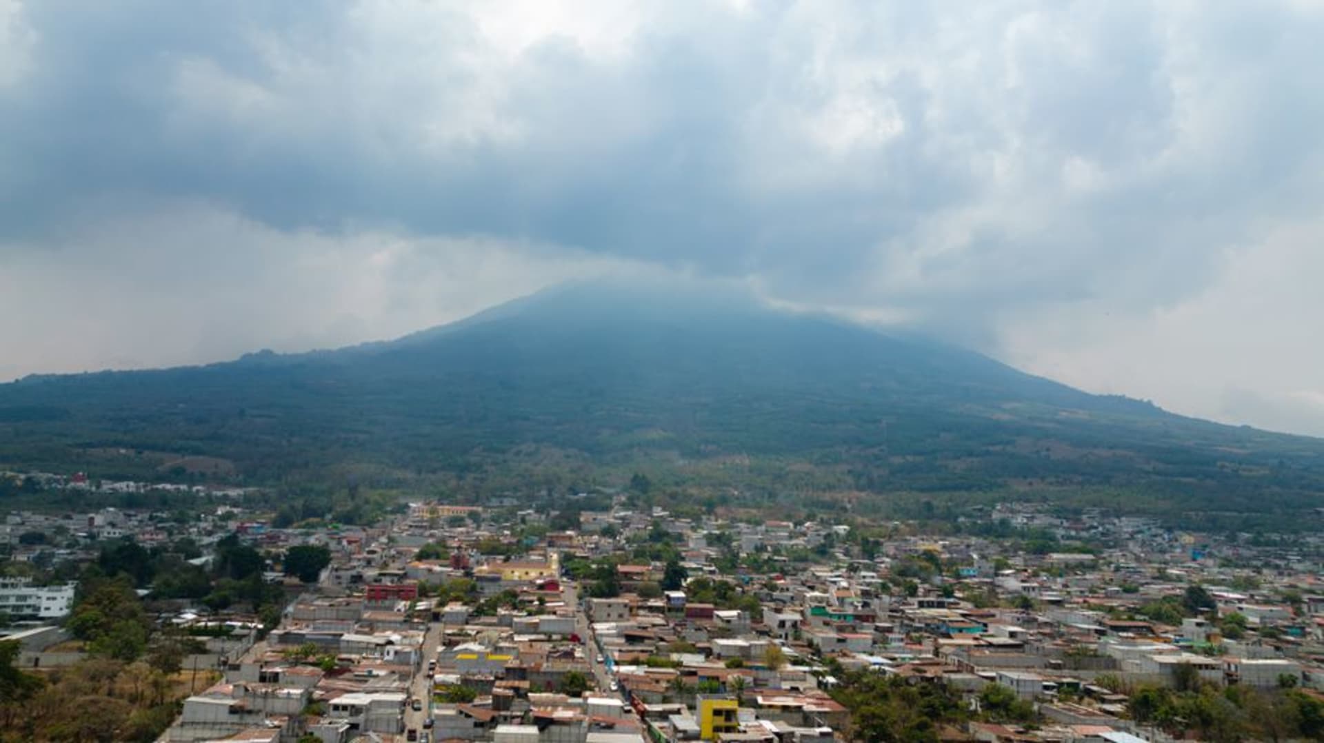 The steep cobblestone streets of Santa María de Jesús with Volcán de Agua rising directly behind the town