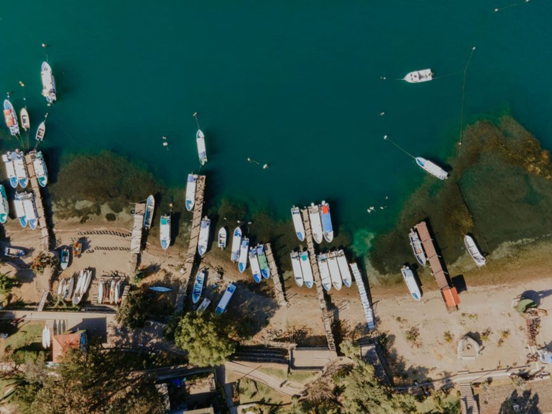 Le front de lac de Santiago Atitlán avec des barques maya tz'utujil et un volcan en arrière-plan