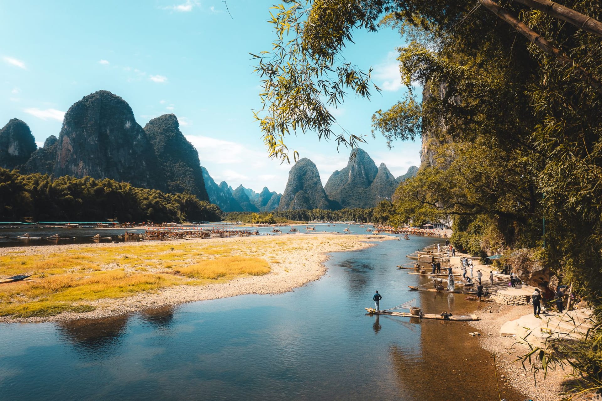 Mist-covered karst limestone peaks reflected in the calm waters of the Li River at dawn near Guilin