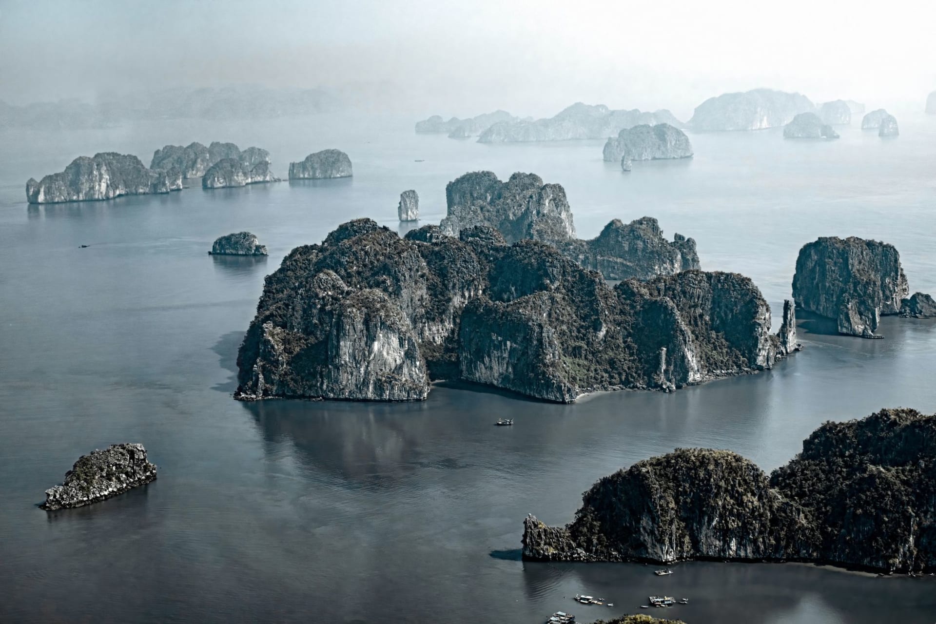 Formations calcaires de karsts vides s'étendant à l'horizon dans la Baie de Bái Tử Long au lever du soleil, l'eau verte sans aucun bateau