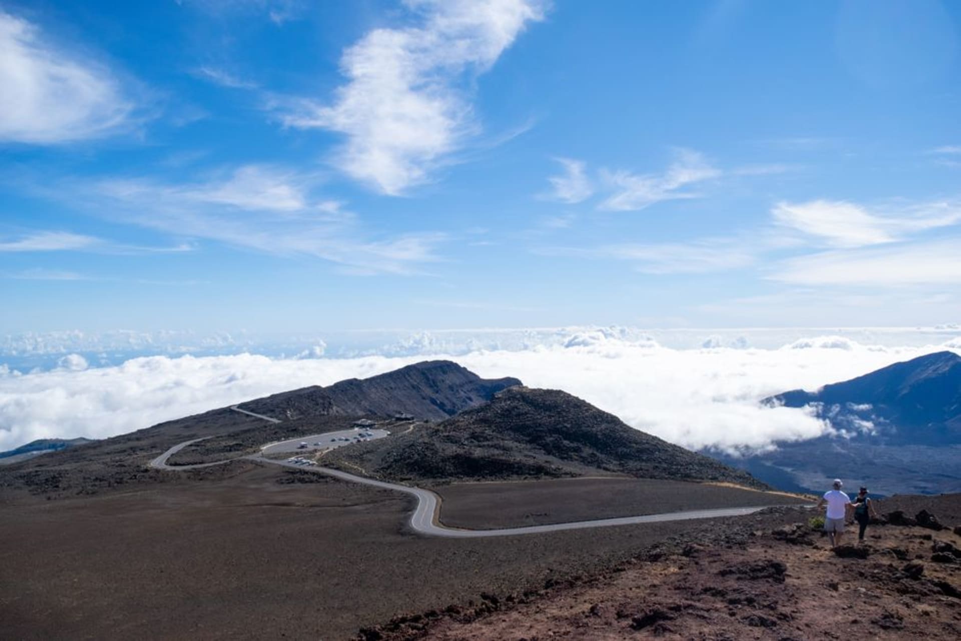 Sunrise light spilling red and gold across the volcanic crater of Haleakala above a sea of clouds