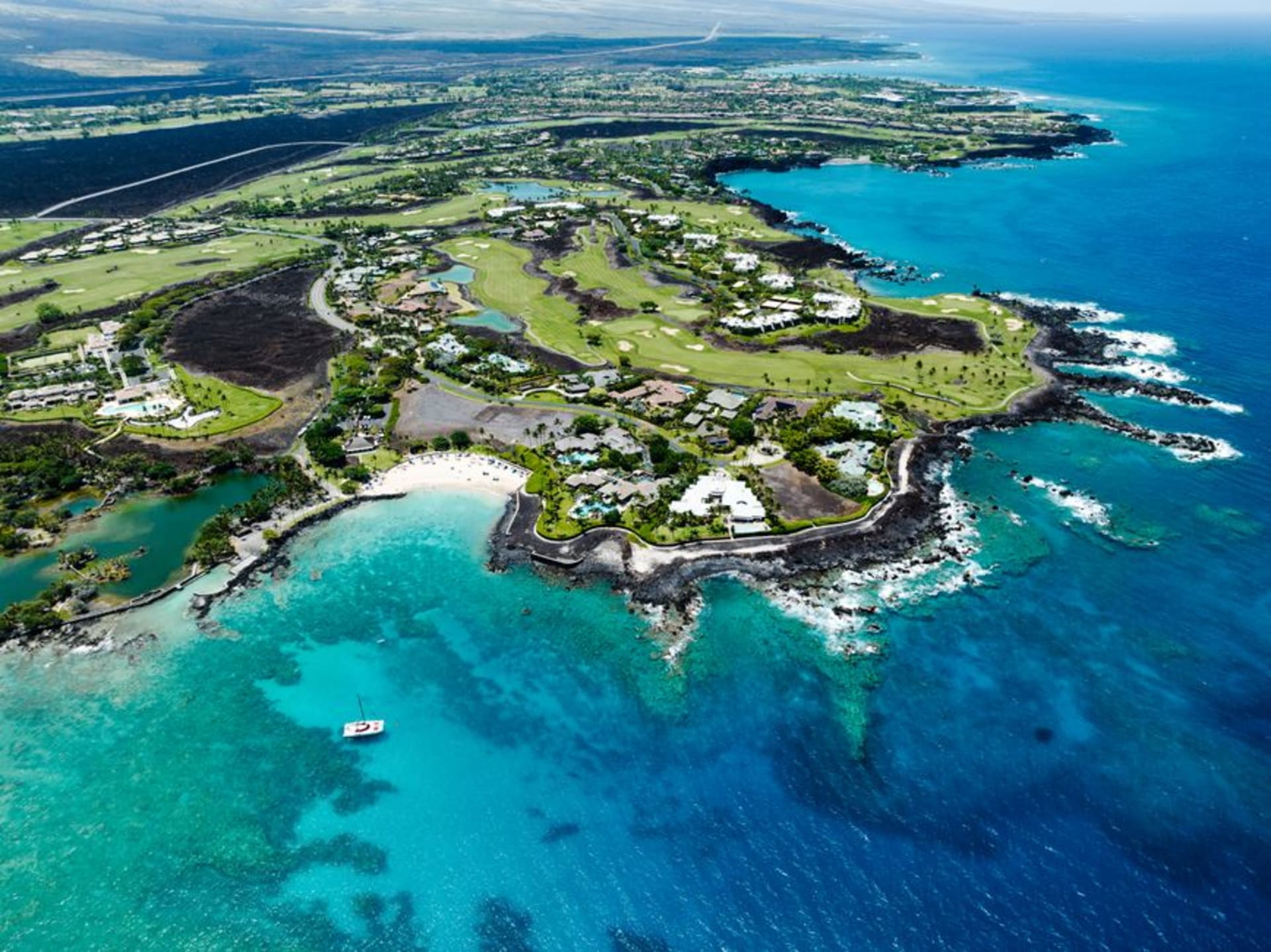 Waikoloa Beach Resort on Hawai'i's Kohala Coast at sunset, with palm-lined lagoons and lava rock in the foreground