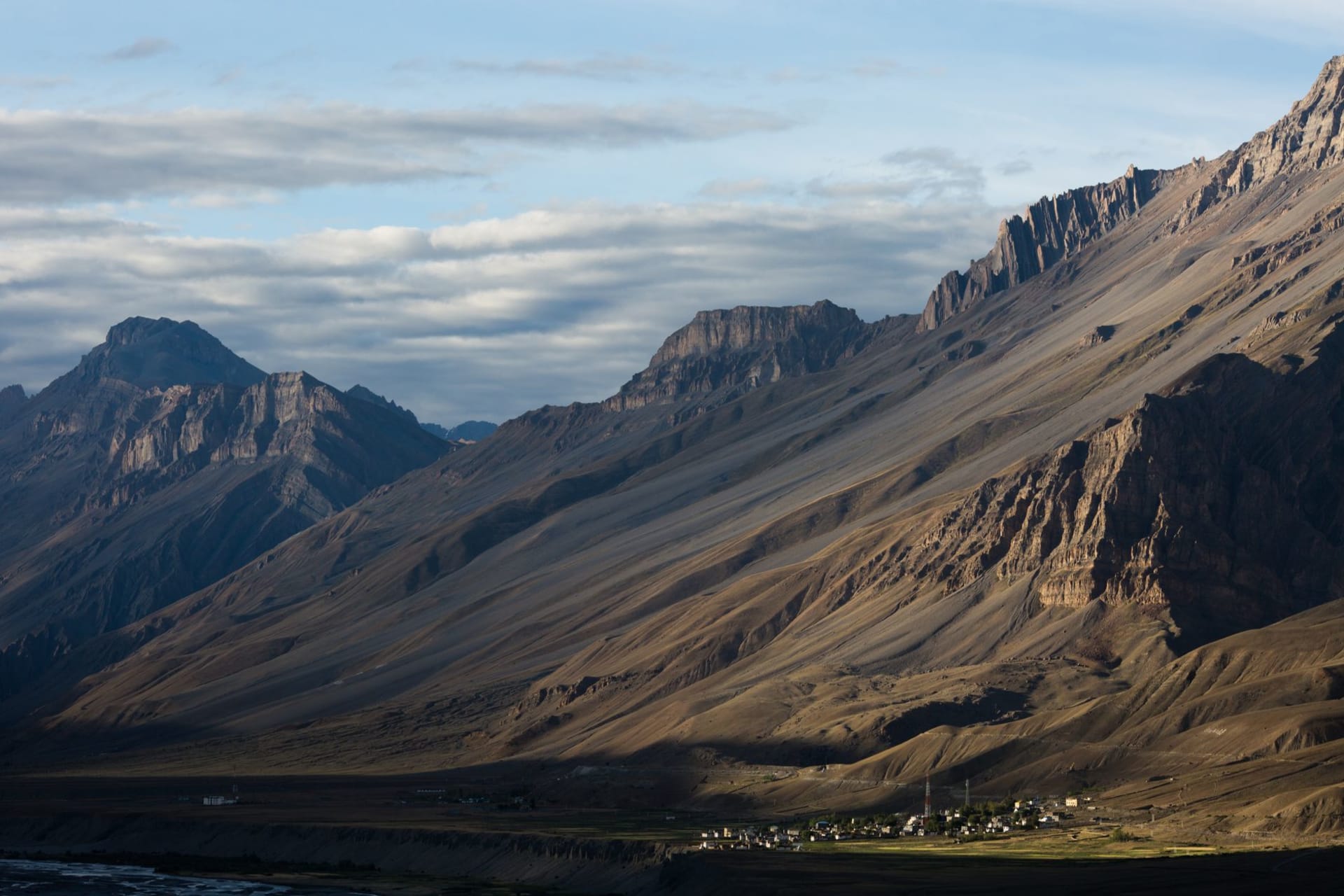 La rivière Spiti serpentant dans une vaste vallée dénudée de roche ocre et grise sous un ciel bleu intense de haute altitude