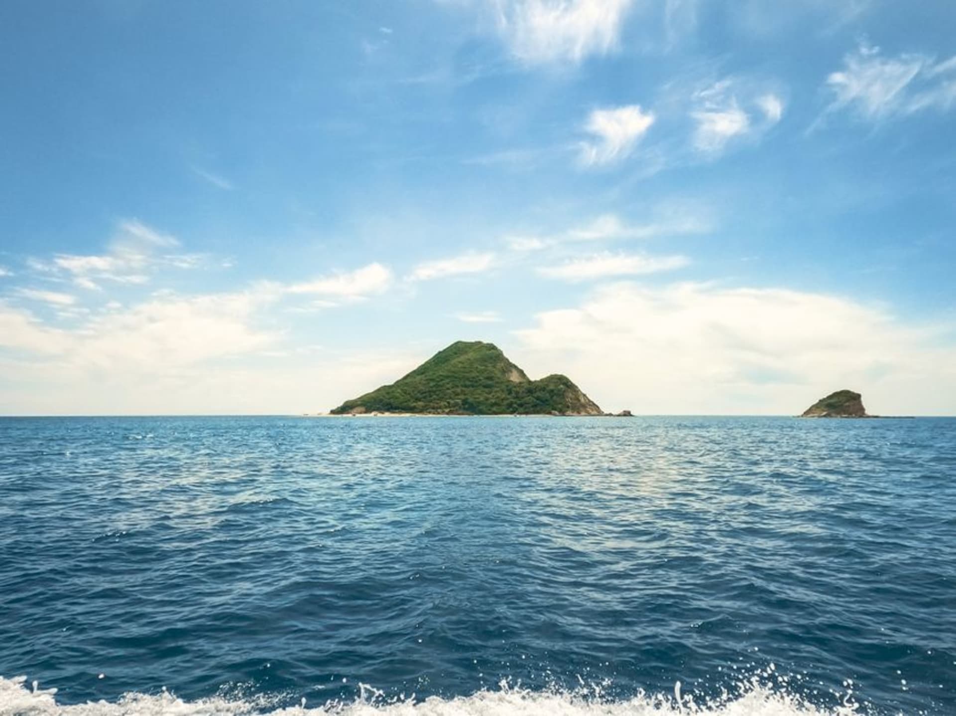 Le mont Rishiri s'élevant en un cône volcanique presque parfait au-dessus de la ville côtière et du port de l'île de Rishiri, vu depuis le ferry