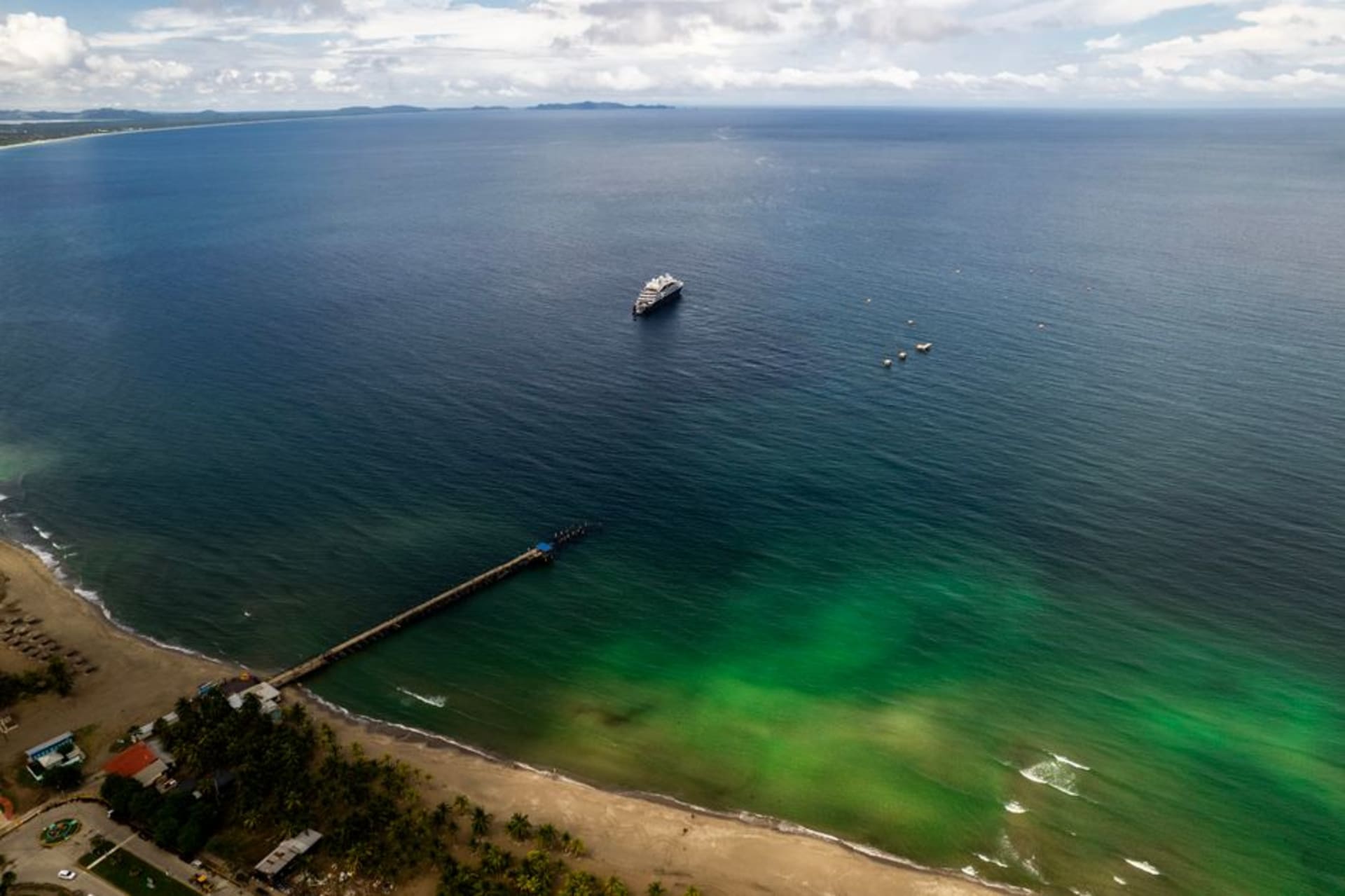 El fuerte colonial de Santa Bárbara de Trujillo con vista a una bahía curva de arena oscura y agua turquesa del Caribe