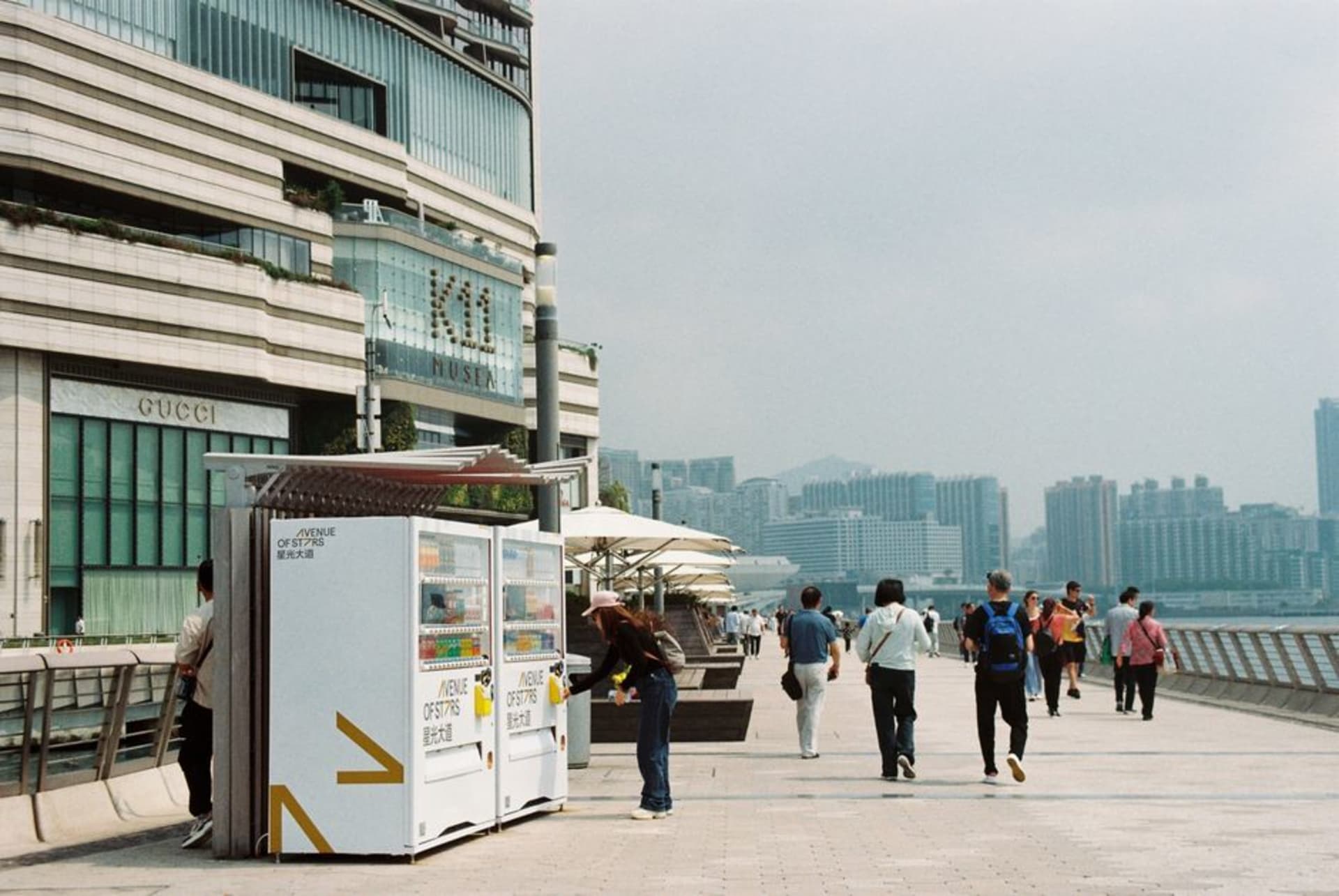 La promenade de l'Avenue of Stars au crépuscule avec la skyline de l'île de Hong Kong scintillant à travers Victoria Harbour