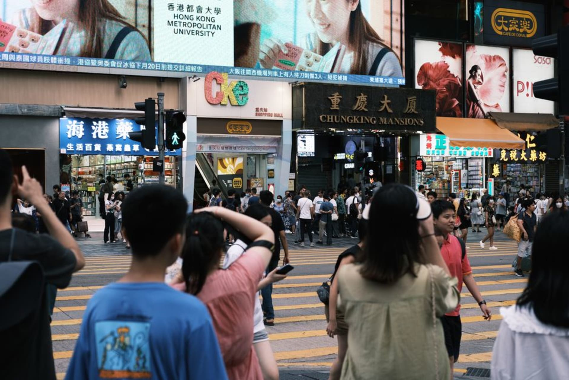 The crowded ground floor arcade of Chungking Mansions in Tsim Sha Tsui, lined with small shops and food stalls